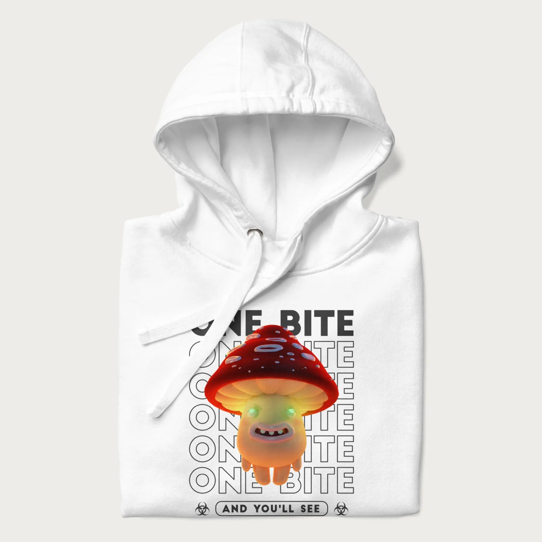 Folded white hoodie with a graphic of a glowing, cartoon realistic mushroom character and the text 'One Bite And You'll See'.