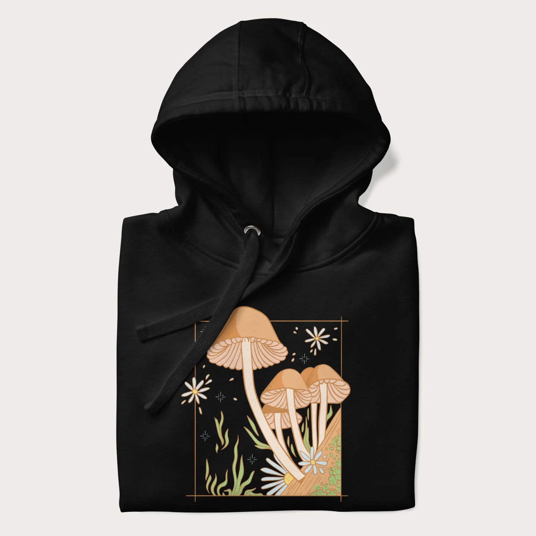 Folded black hoodie with a detailed cottagecore illustration of Psilocybe mushrooms and flowers.