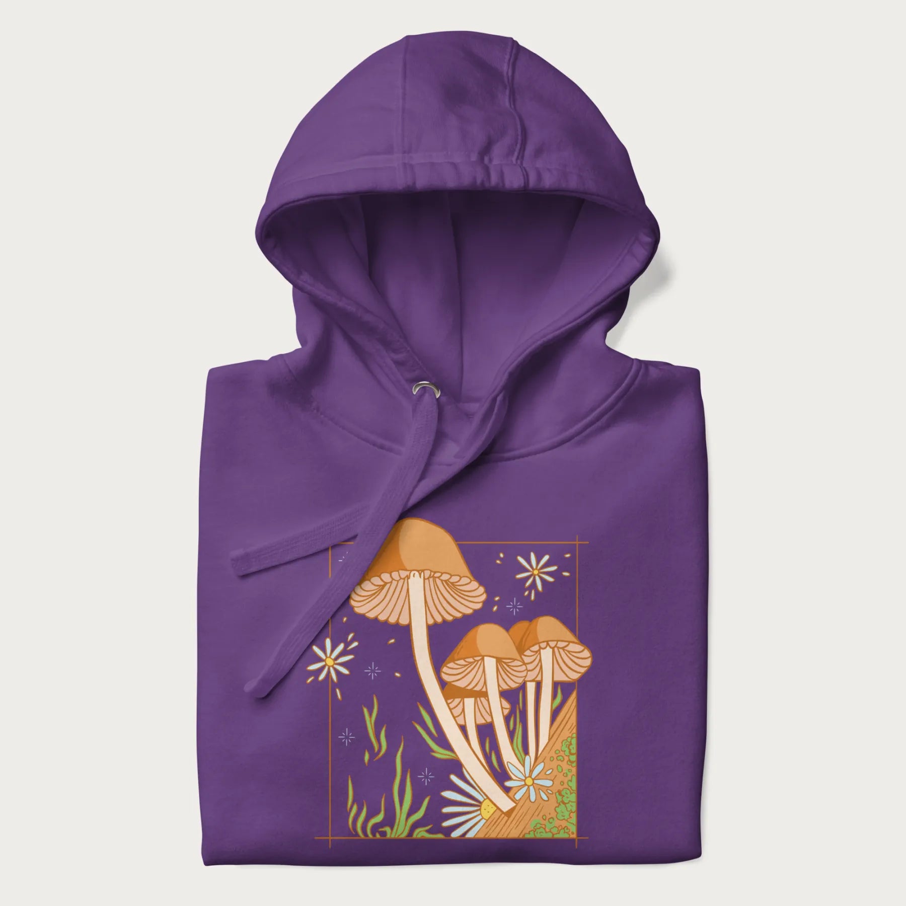 Folded purple hoodie with a detailed cottagecore illustration of Psilocybe mushrooms and flowers.