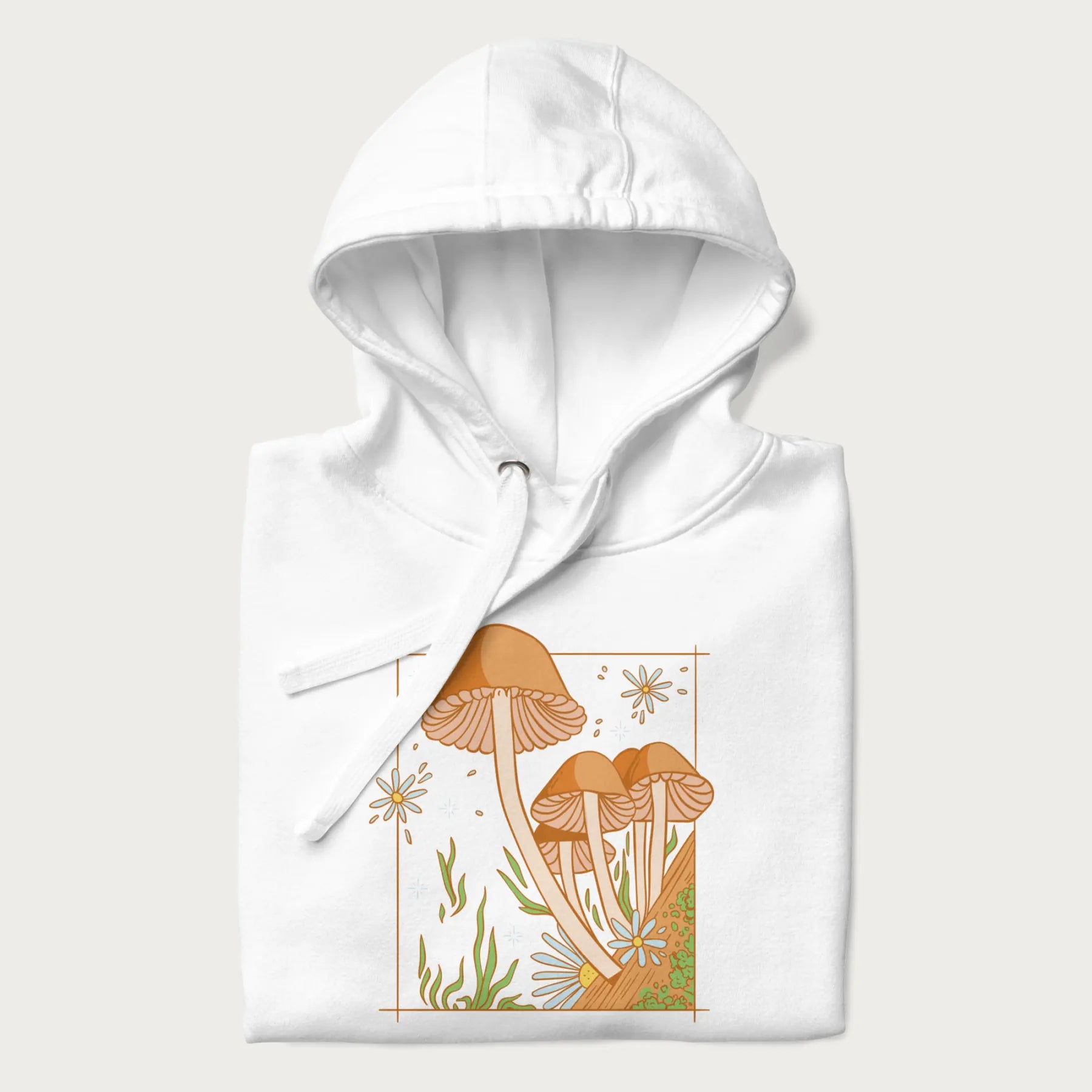 Folded white hoodie with a detailed cottagecore illustration of Psilocybe mushrooms and flowers.