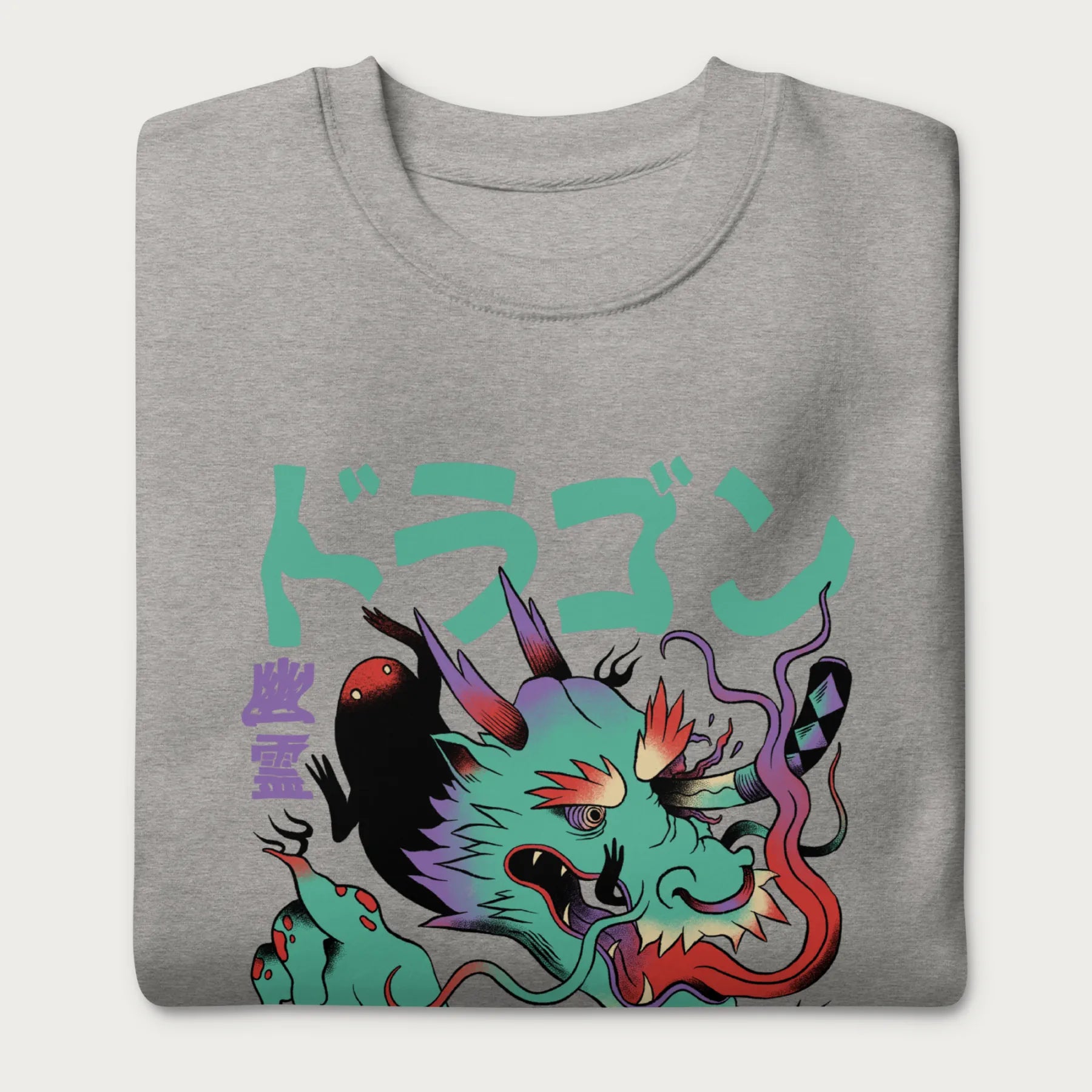 Folded light grey sweatshirt with a Japanese dragon graphic featuring vibrant colors and Japanese text.
