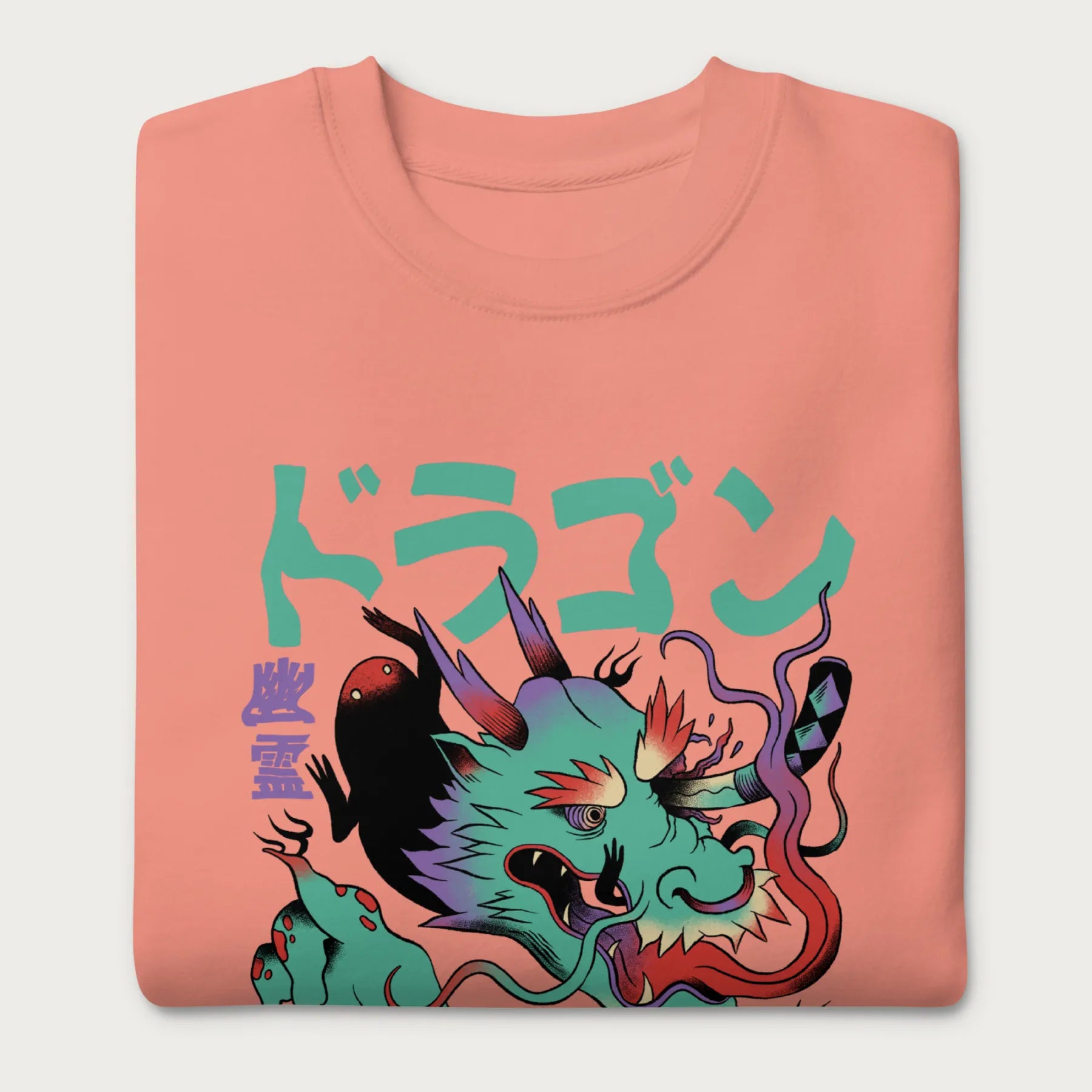 Folded light pink sweatshirt with a Japanese dragon graphic featuring vibrant colors and Japanese text.