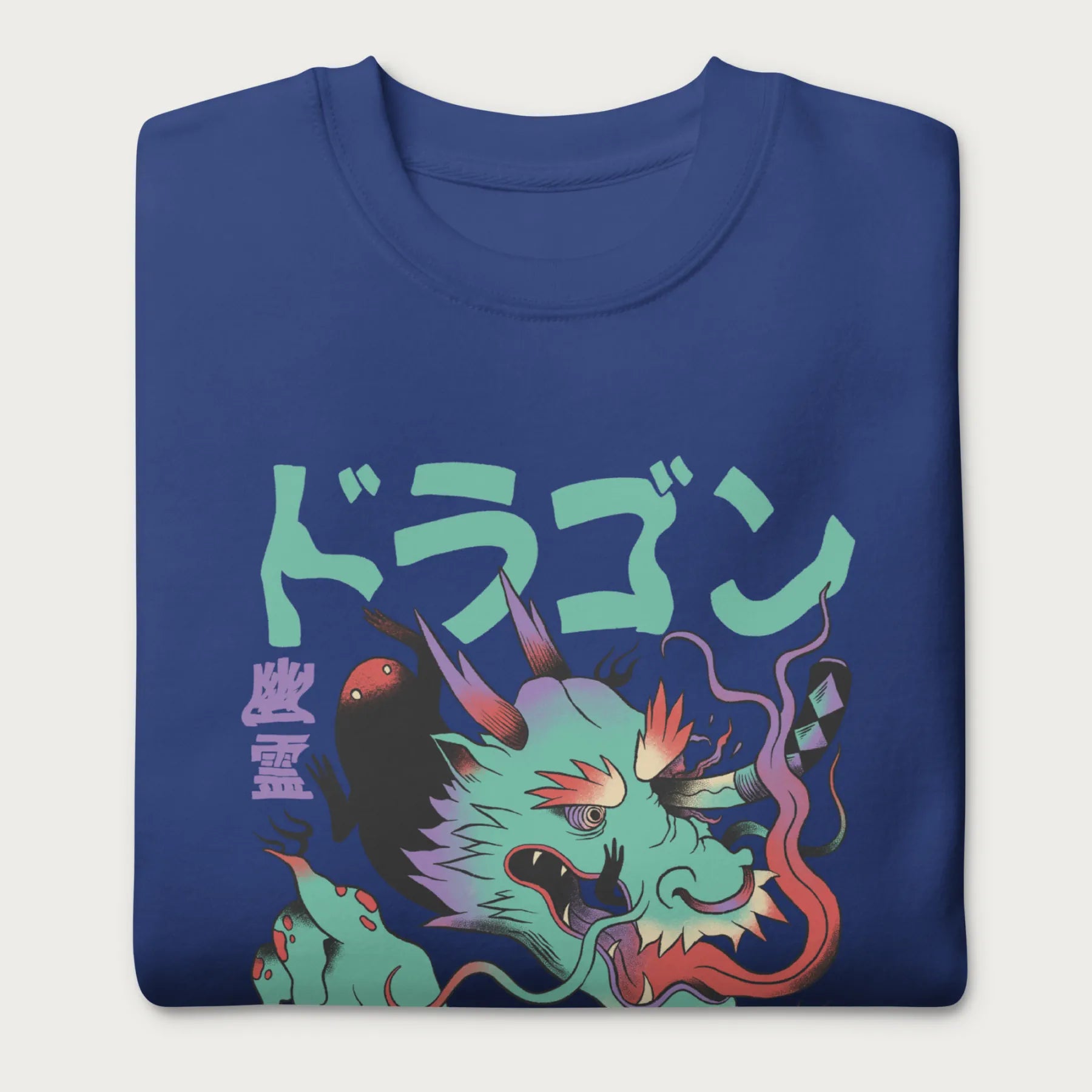 Folded royal blue sweatshirt with a Japanese dragon graphic featuring vibrant colors and Japanese text.