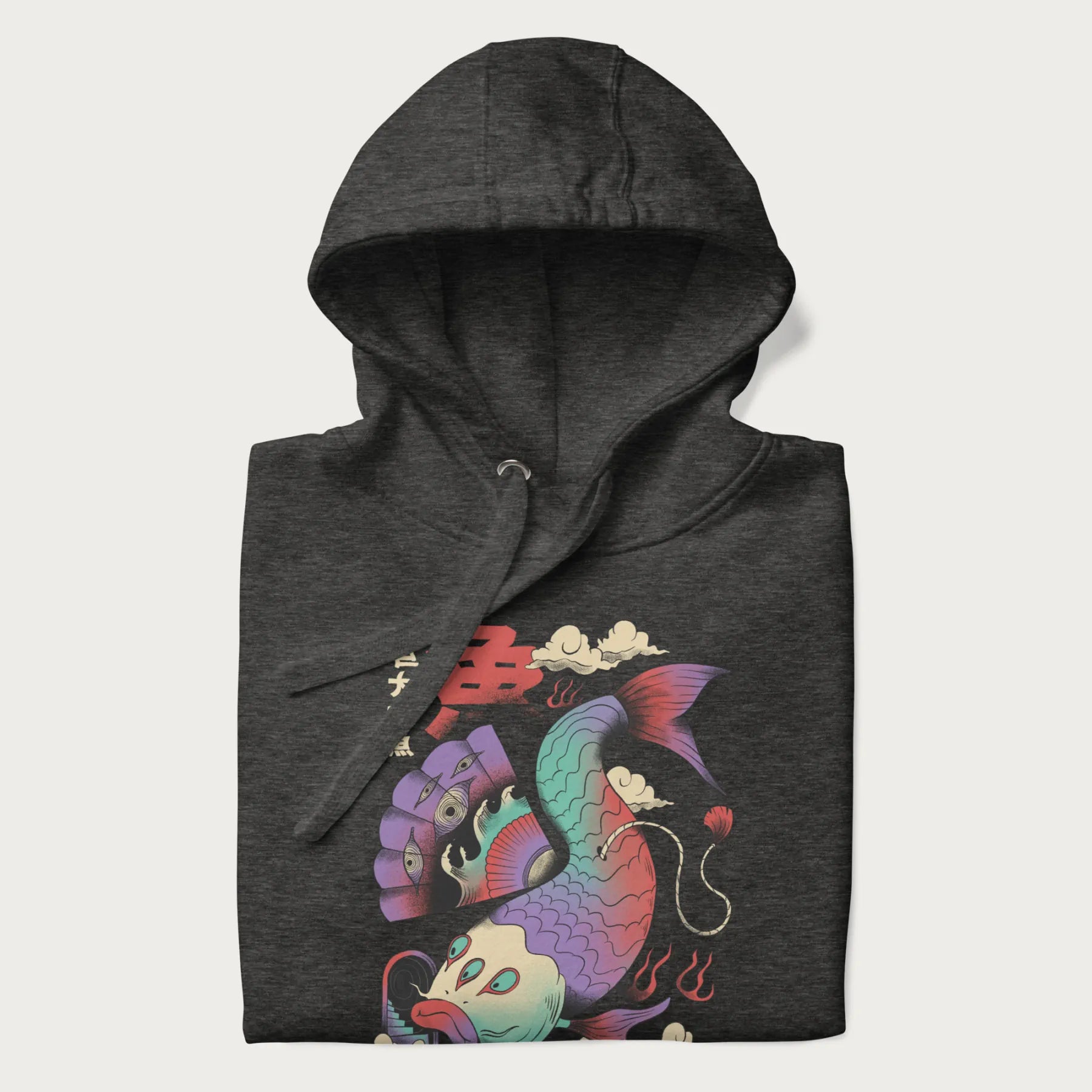 Folded dark grey hoodie with Japanese graphic of a colorful psychedelic koi fish, with Japanese text '魚' (Fish) and '巨大な魚' (Giant Fish).