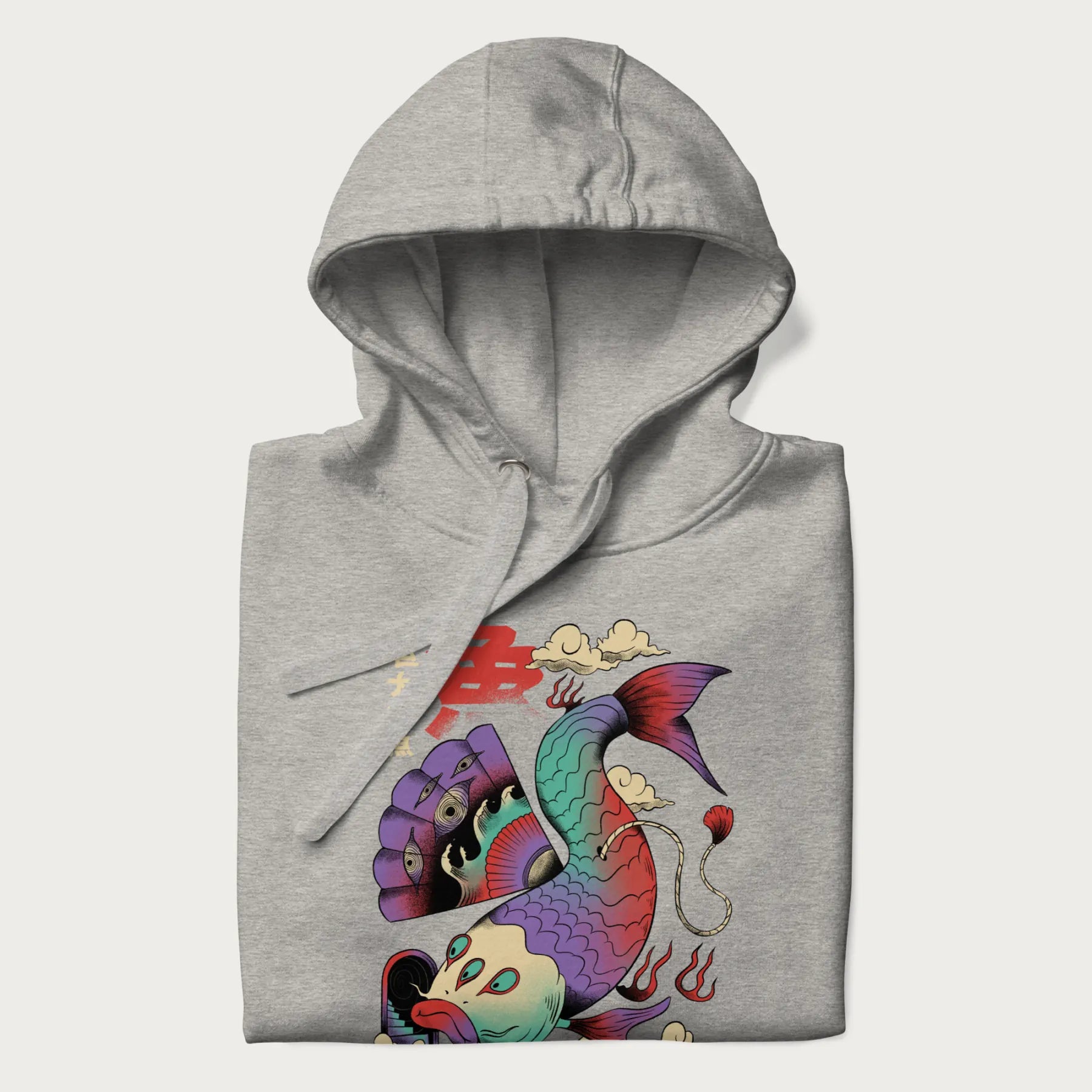 Folded light grey hoodie with Japanese graphic of a colorful psychedelic koi fish, with Japanese text '魚' (Fish) and '巨大な魚' (Giant Fish).