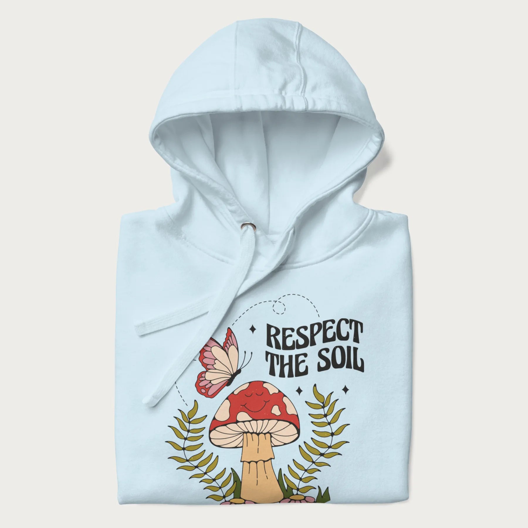 Folded light blue hoodie with mushroom and butterfly design, with the text 'Respect the Soil' above it.