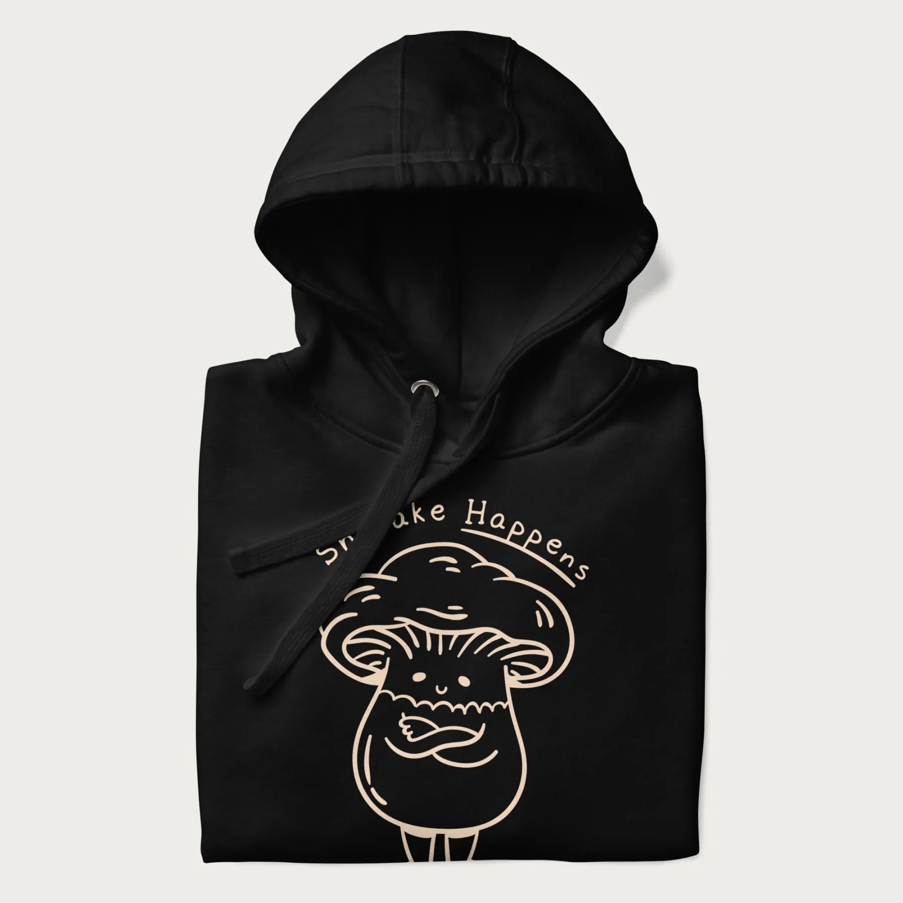 Folded black hoodie featuring a cute shiitake mushroom graphic with the text "Shiitake Happens."