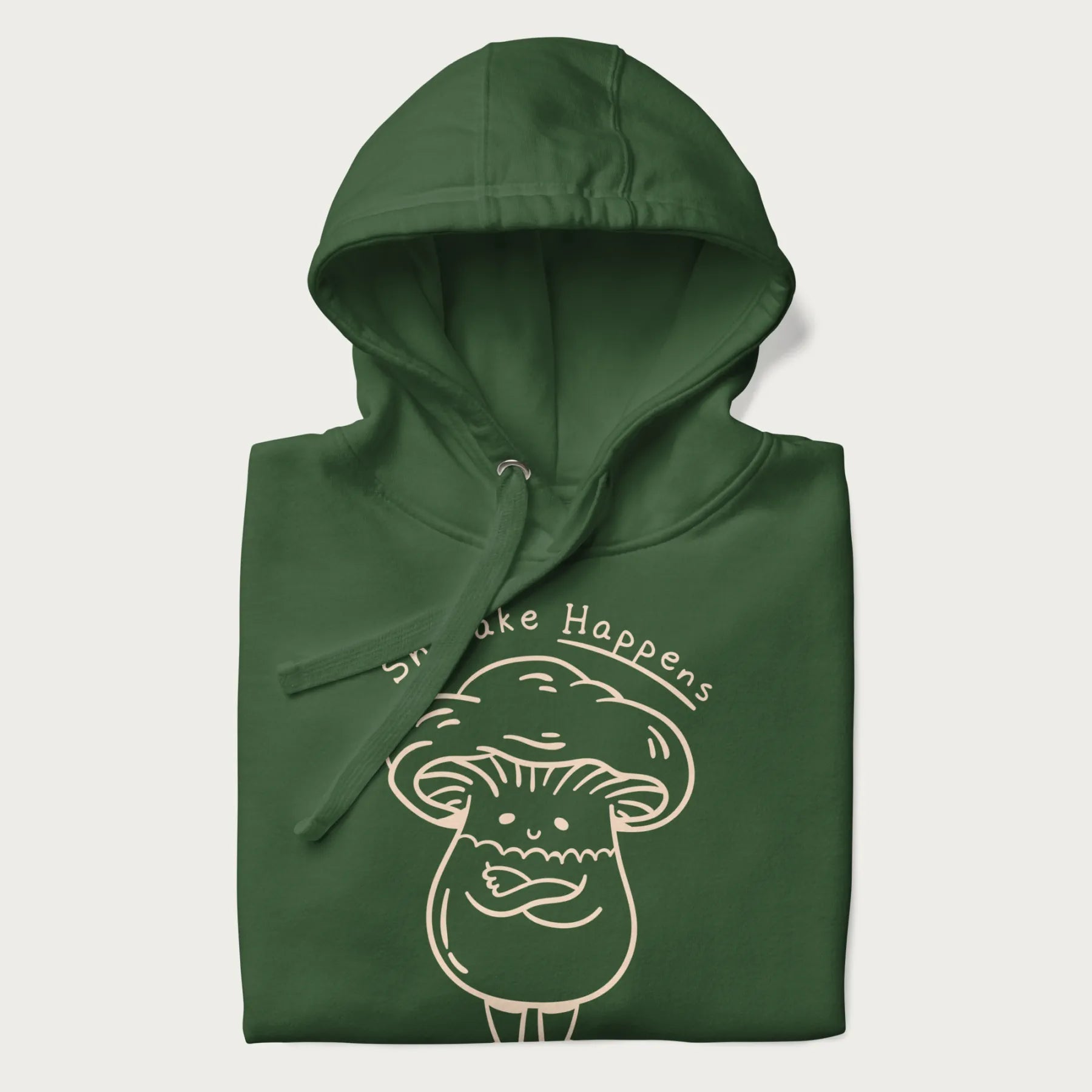 Folded forest green hoodie featuring a cute shiitake mushroom graphic with the text "Shiitake Happens."