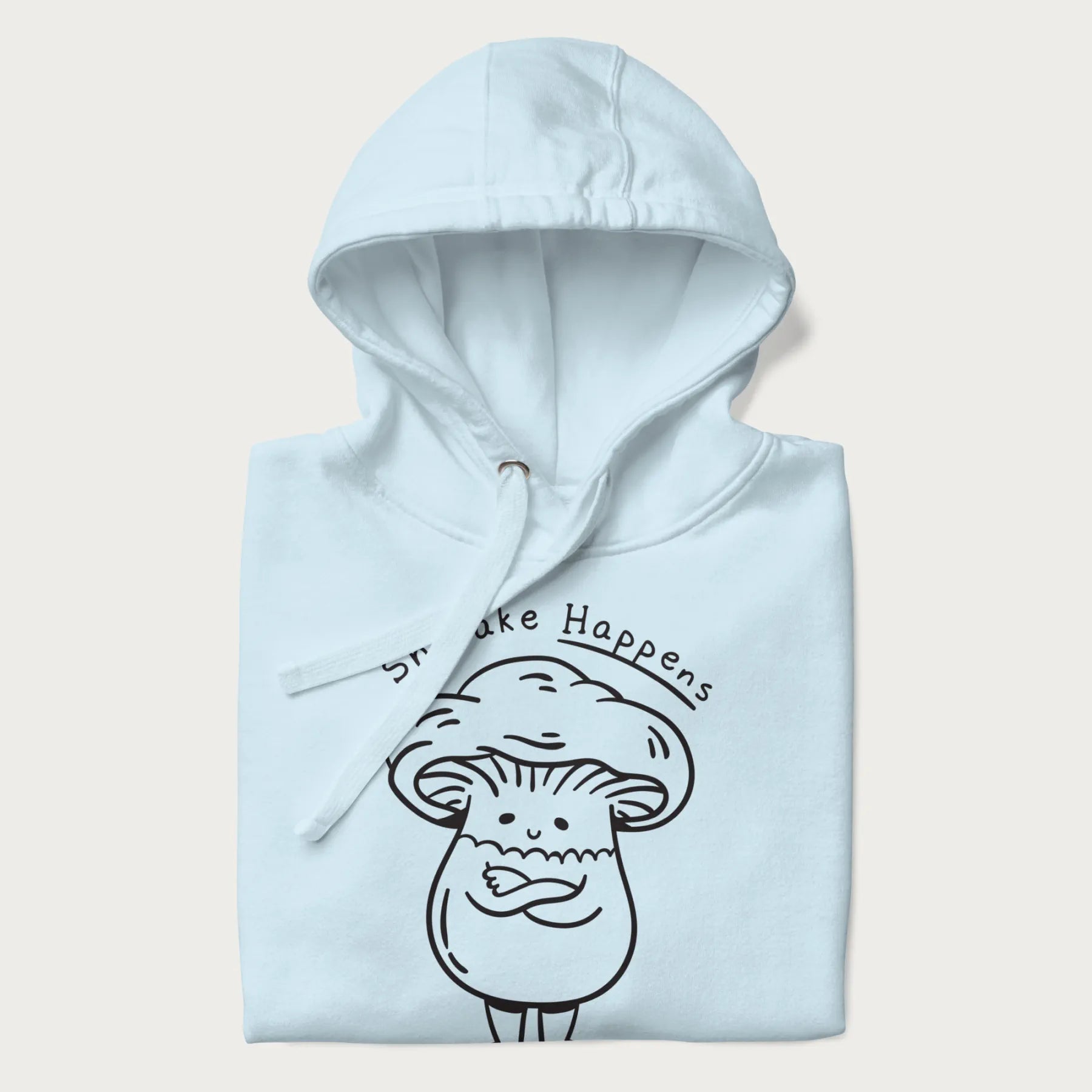 Folded light blue hoodie featuring a cute shiitake mushroom graphic with the text "Shiitake Happens."
