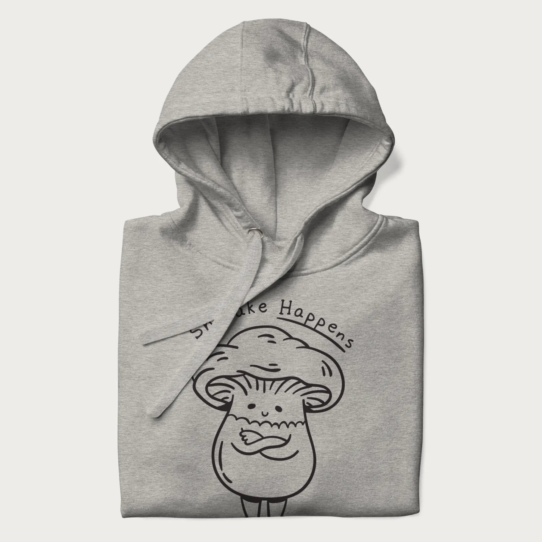 Folded light grey hoodie featuring a cute shiitake mushroom graphic with the text "Shiitake Happens."
