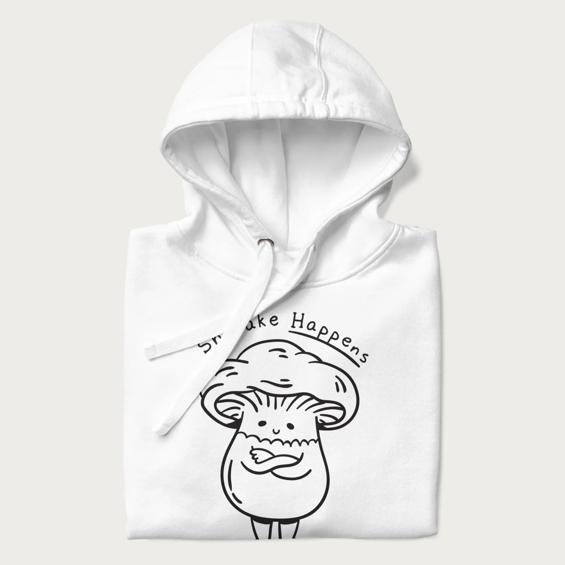 Folded white hoodie featuring a cute shiitake mushroom graphic with the text "Shiitake Happens."