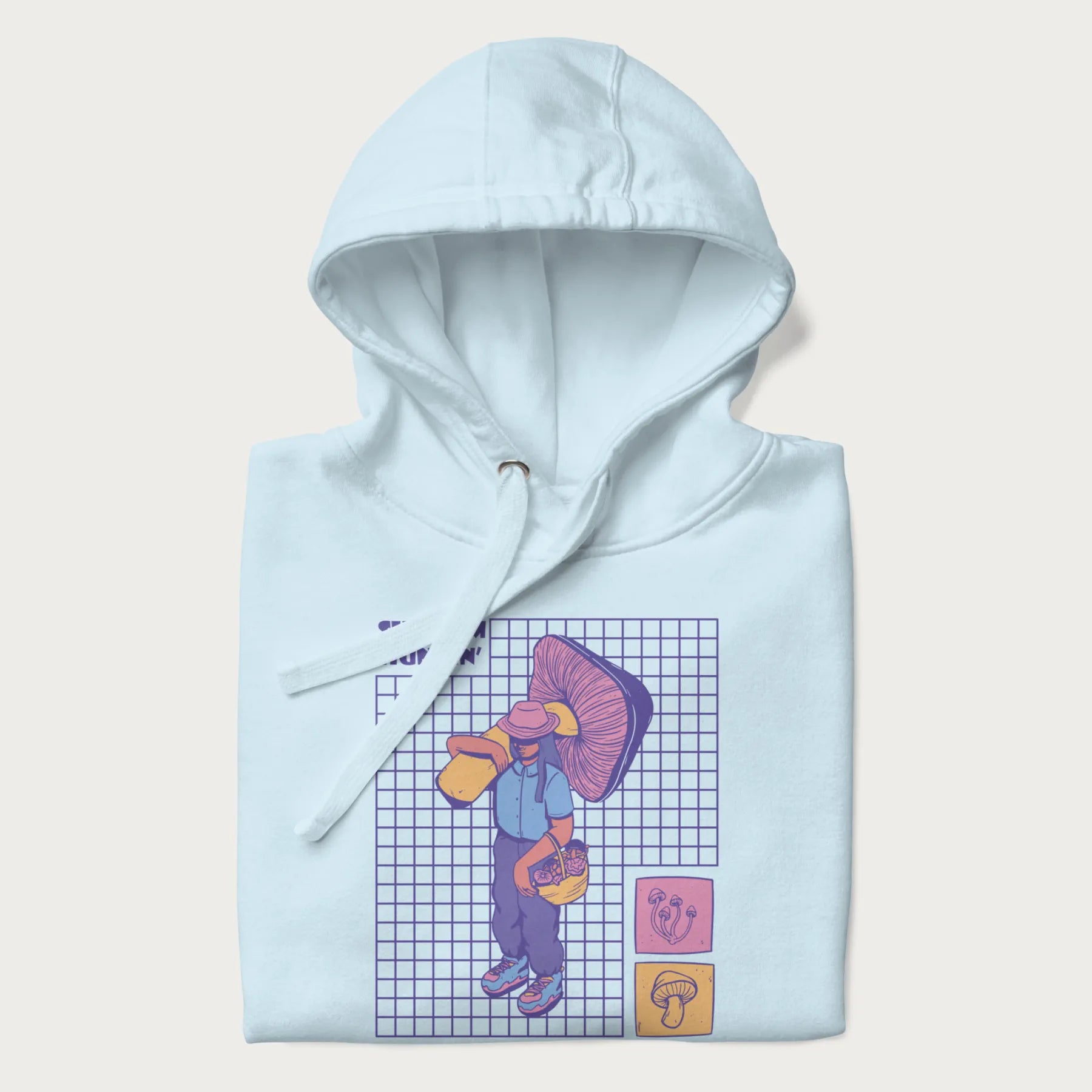 Folded light blue hoodie featuring a graphic of a girl carrying a large mushroom and a basket of fungi, with the text "Shroom Huntin'".