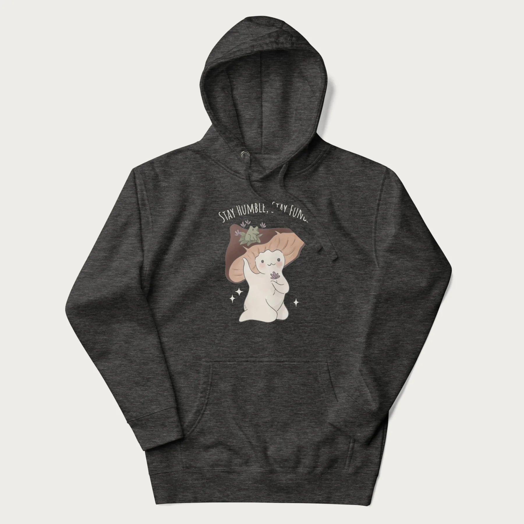 Dark grey hoodie with graphic of a cute mushroom character holding a flower with a frog on its cap and the text 'Stay Humble, Stay Fungi' above.
