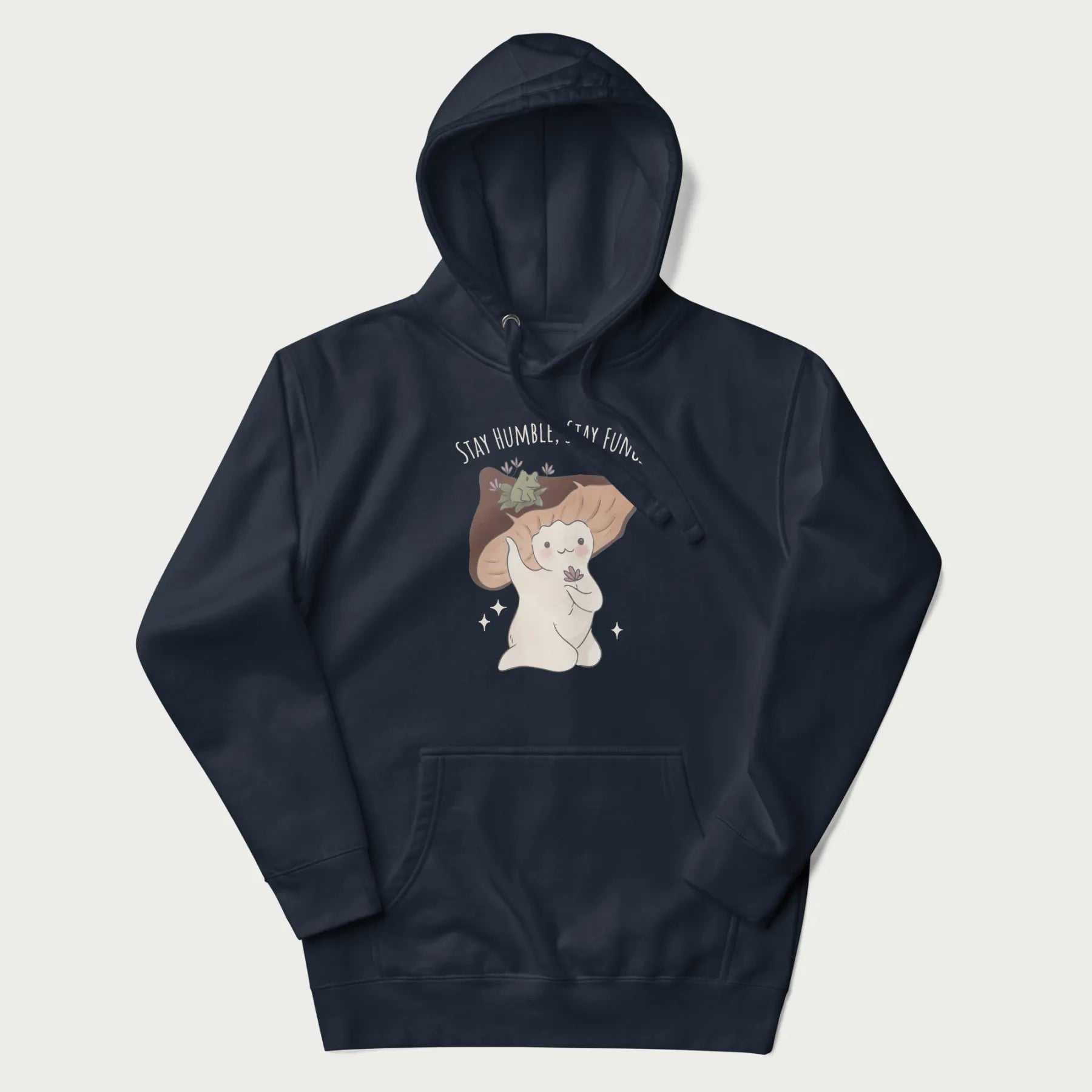 Navy blue hoodie with graphic of a cute mushroom character holding a flower with a frog on its cap and the text 'Stay Humble, Stay Fungi' above.