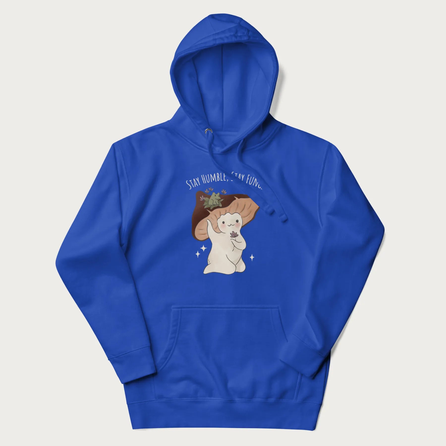 Royal blue hoodie with graphic of a cute mushroom character holding a flower with a frog on its cap and the text 'Stay Humble, Stay Fungi' above.
