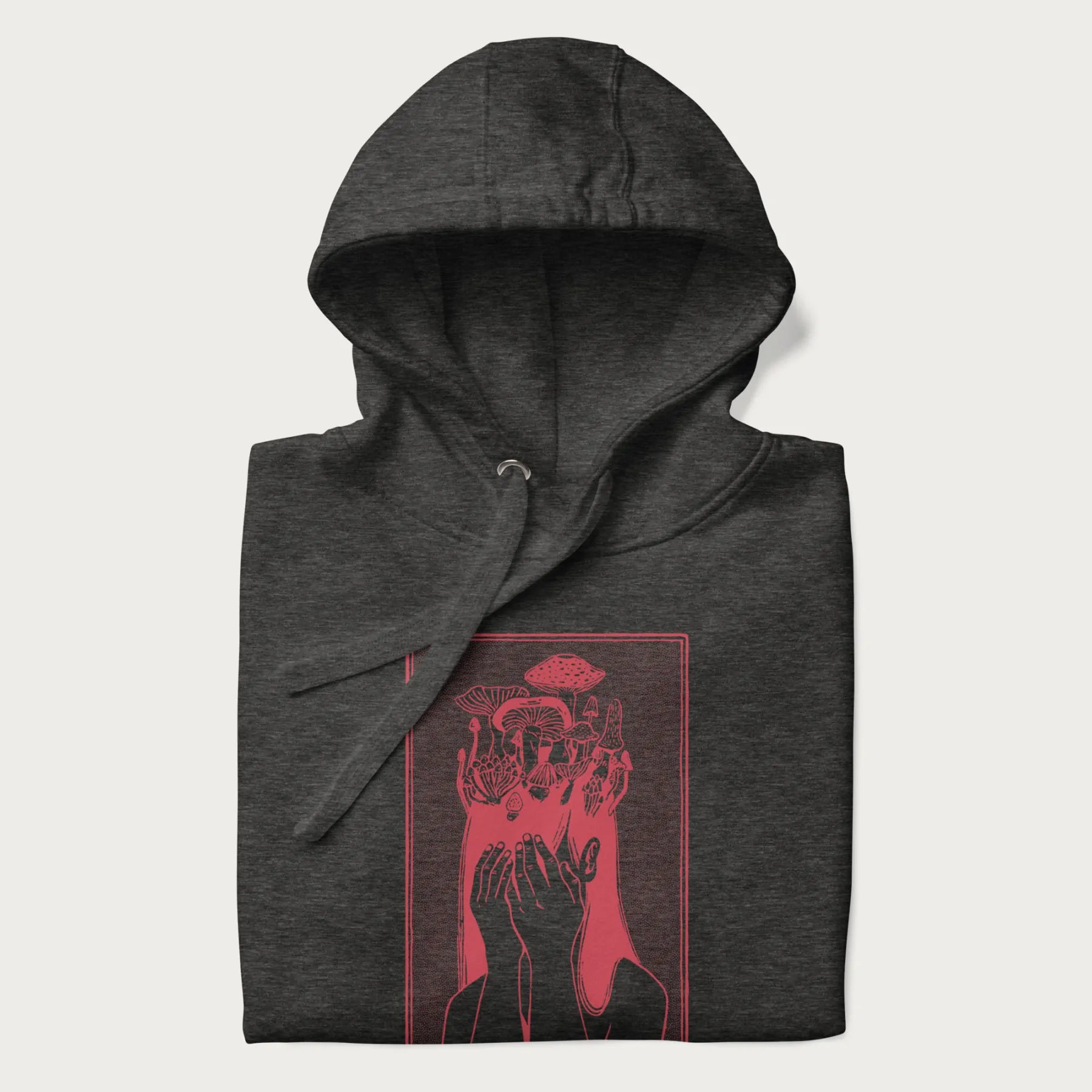 Folded dark grey hoodie with a surreal red graphic of a girl with mushrooms growing from her head.