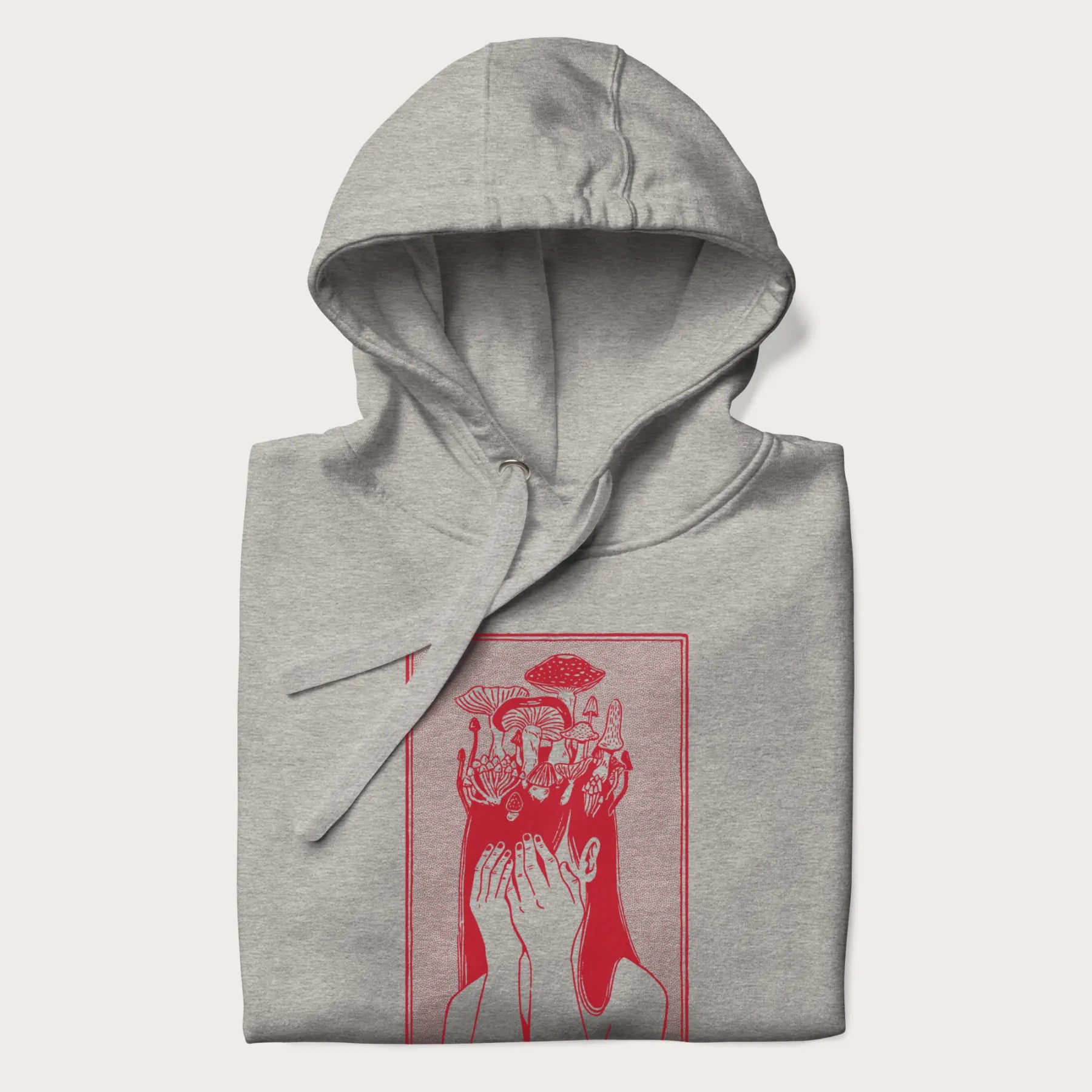 Folded light grey hoodie with a surreal red graphic of a girl with mushrooms growing from her head.