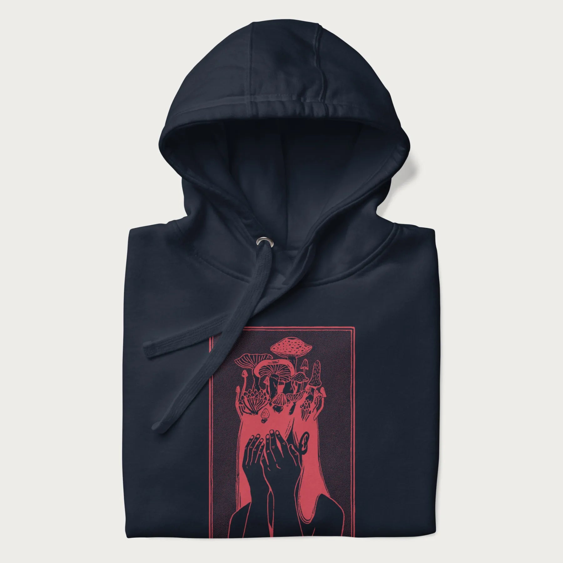 Folded navy blue hoodie with a surreal red graphic of a girl with mushrooms growing from her head.