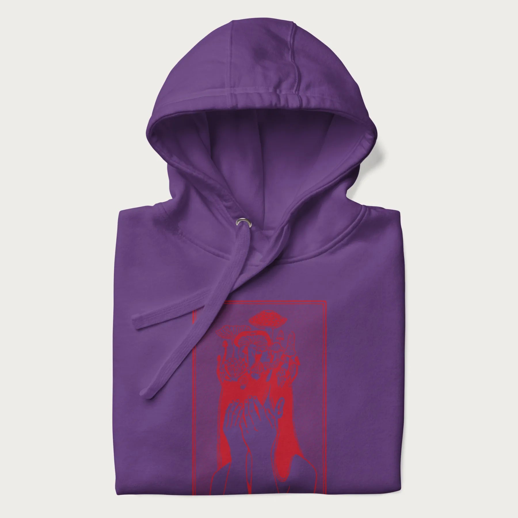 Folded purple hoodie with a surreal red graphic of a girl with mushrooms growing from her head.