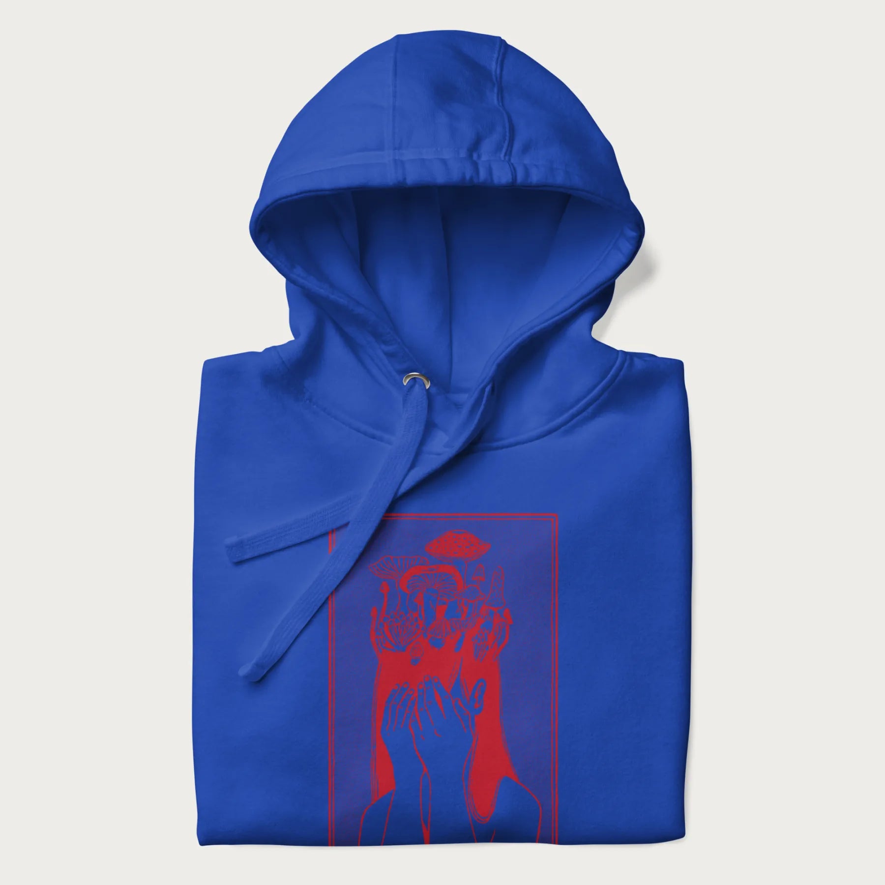 Folded royal blue hoodie with a surreal red graphic of a girl with mushrooms growing from her head.