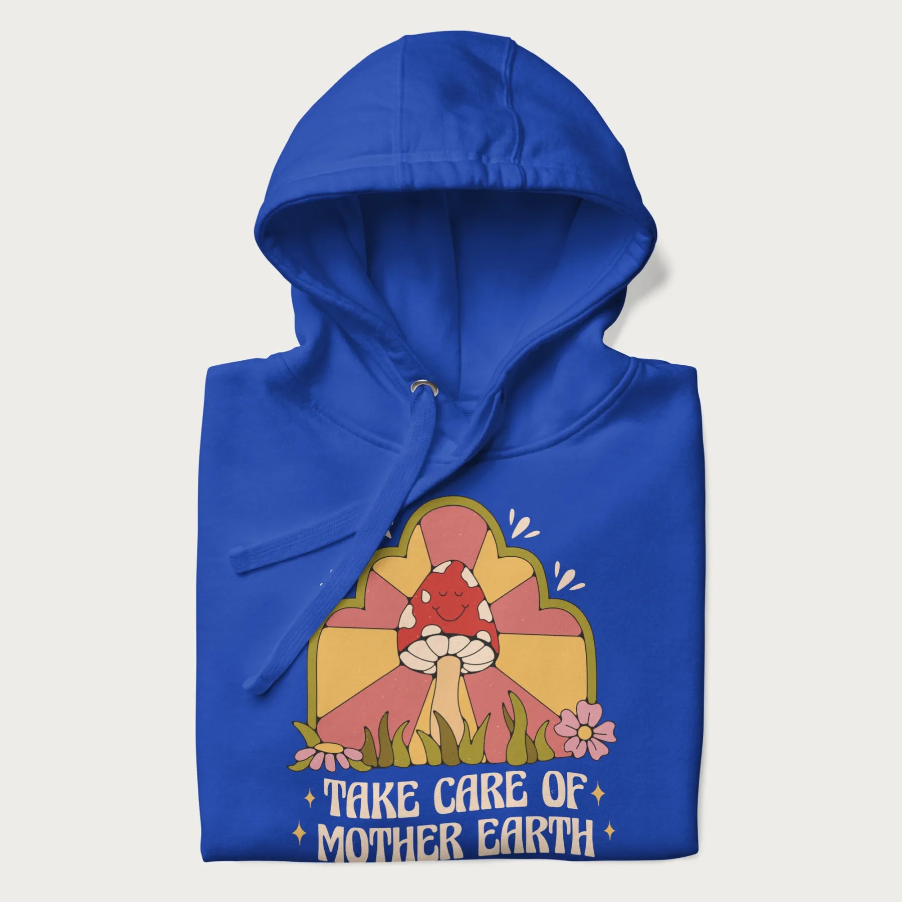 Folded royal blue hoodie with a graphic of a happy red mushroom, sunburst background, and the text 'Take Care of Mother Earth'.