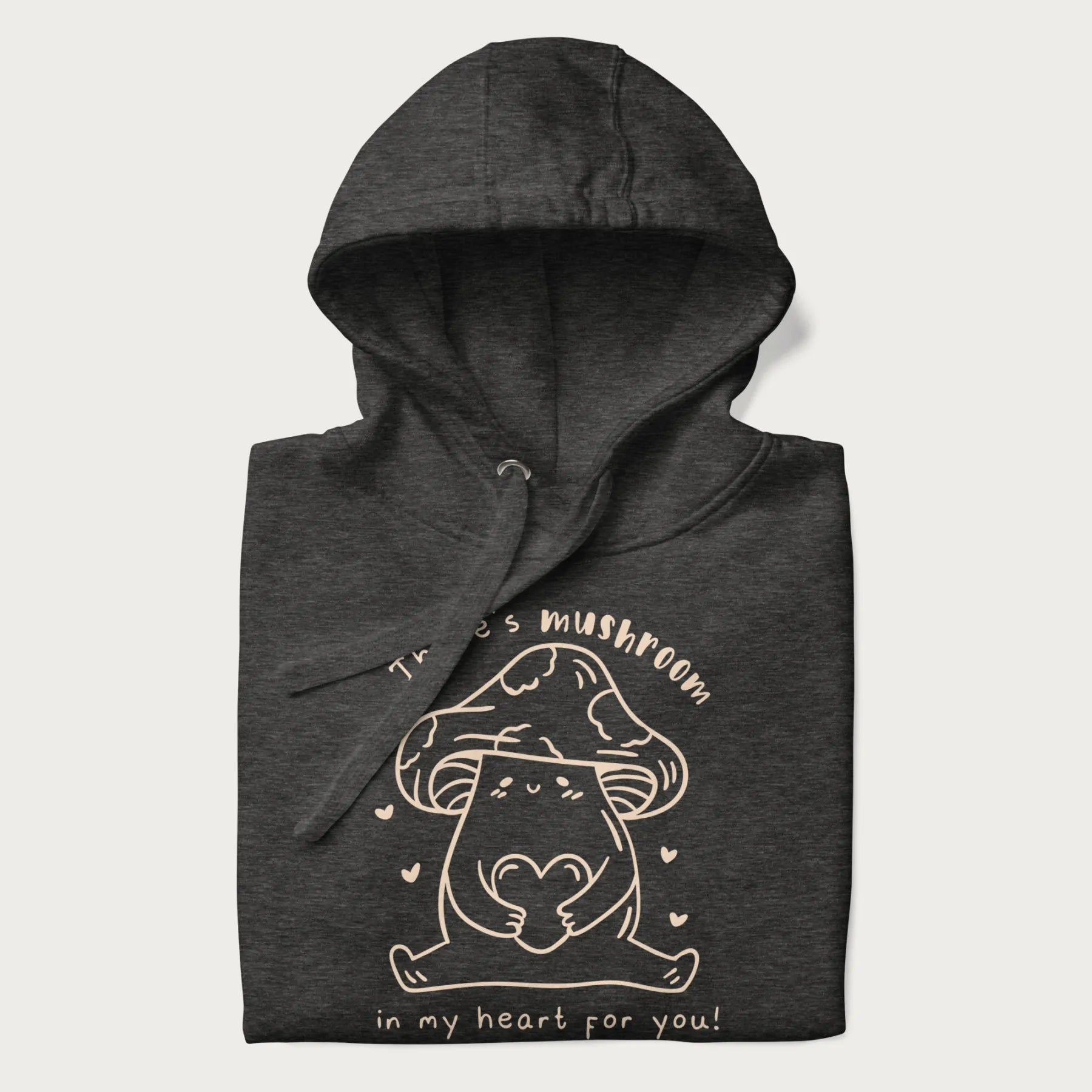 Folded dark grey hoodie with graphic of a cute mushroom holding a heart with the text "There's Mushroom in My Heart for You!"