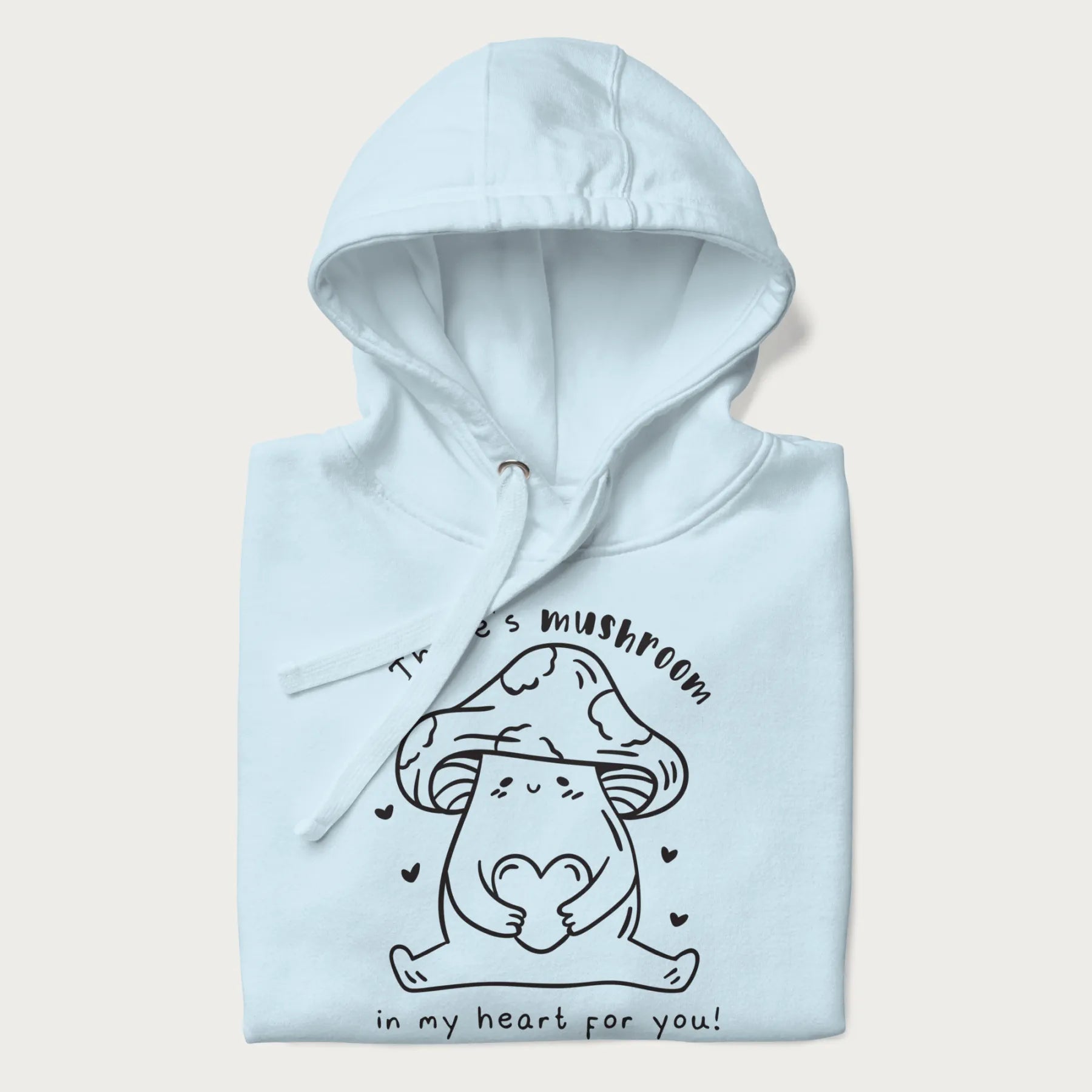 Folded light blue hoodie with graphic of a cute mushroom holding a heart with the text "There's Mushroom in My Heart for You!"