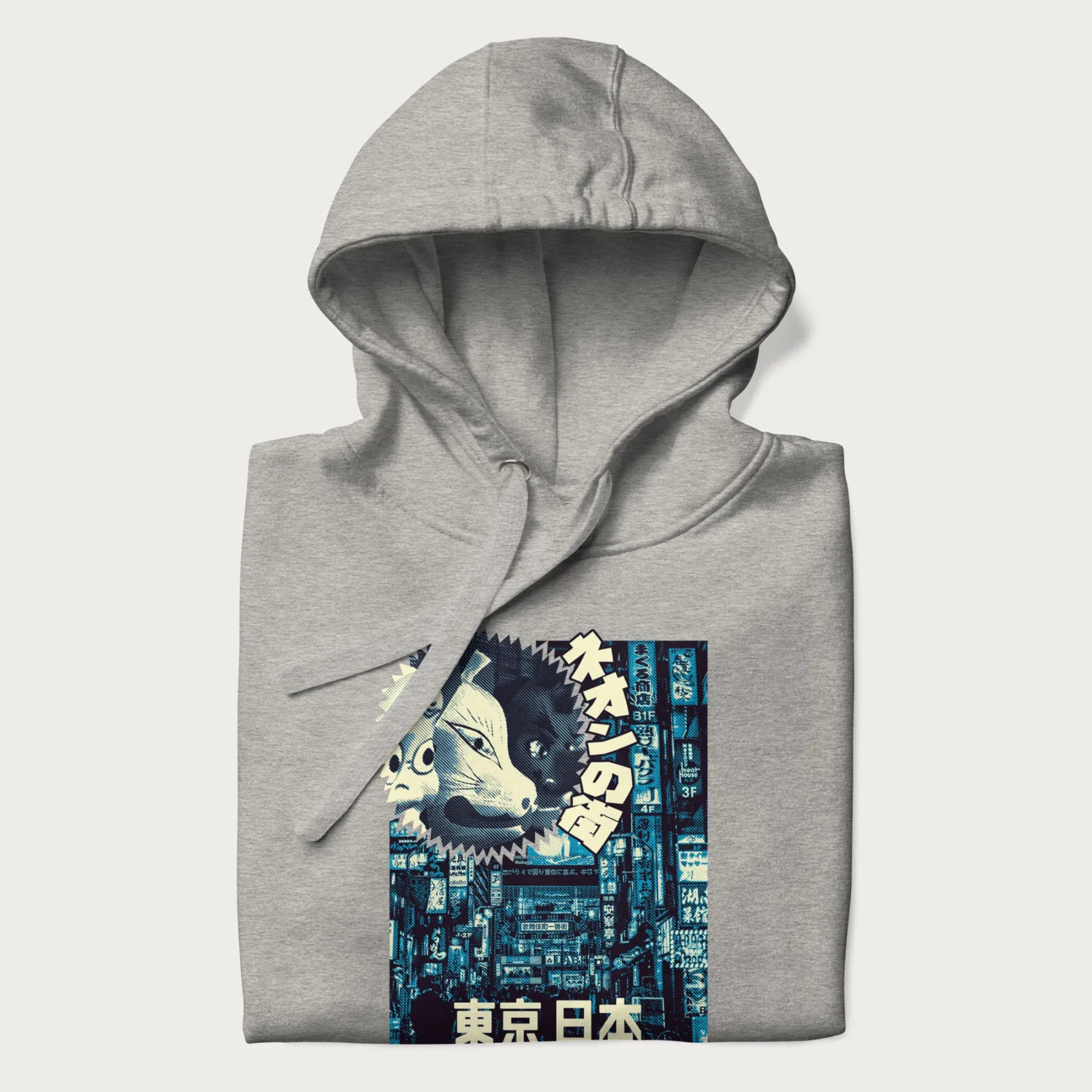Folded light grey hoodie with Japanese text '東京日本' translating to 'Tokyo, Japan', with three traditional Japanese masks over a neon-lit Tokyo background.