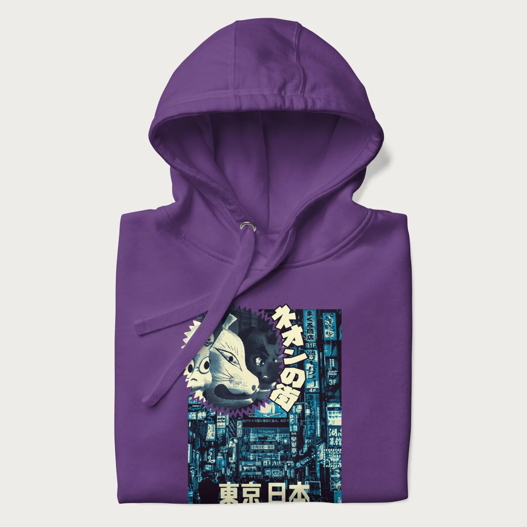 Folded purple hoodie with Japanese text '東京日本' translating to 'Tokyo, Japan', with three traditional Japanese masks over a neon-lit Tokyo background.
