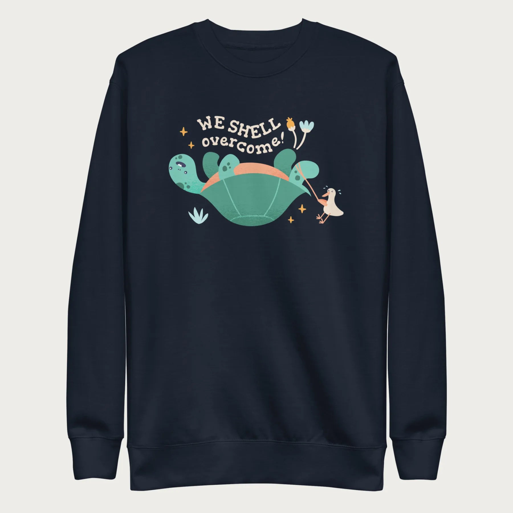 Navy blue sweatshirt with a graphic of a turtle flipped on it's shell with the phrase 'We Shell Overcome.'