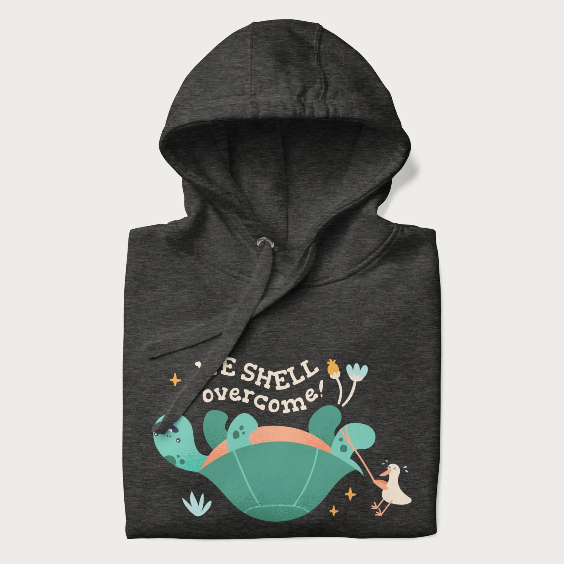 Folded dark grey hoodie with graphic of a turtle and a duck with the text 'We Shell Overcome'.