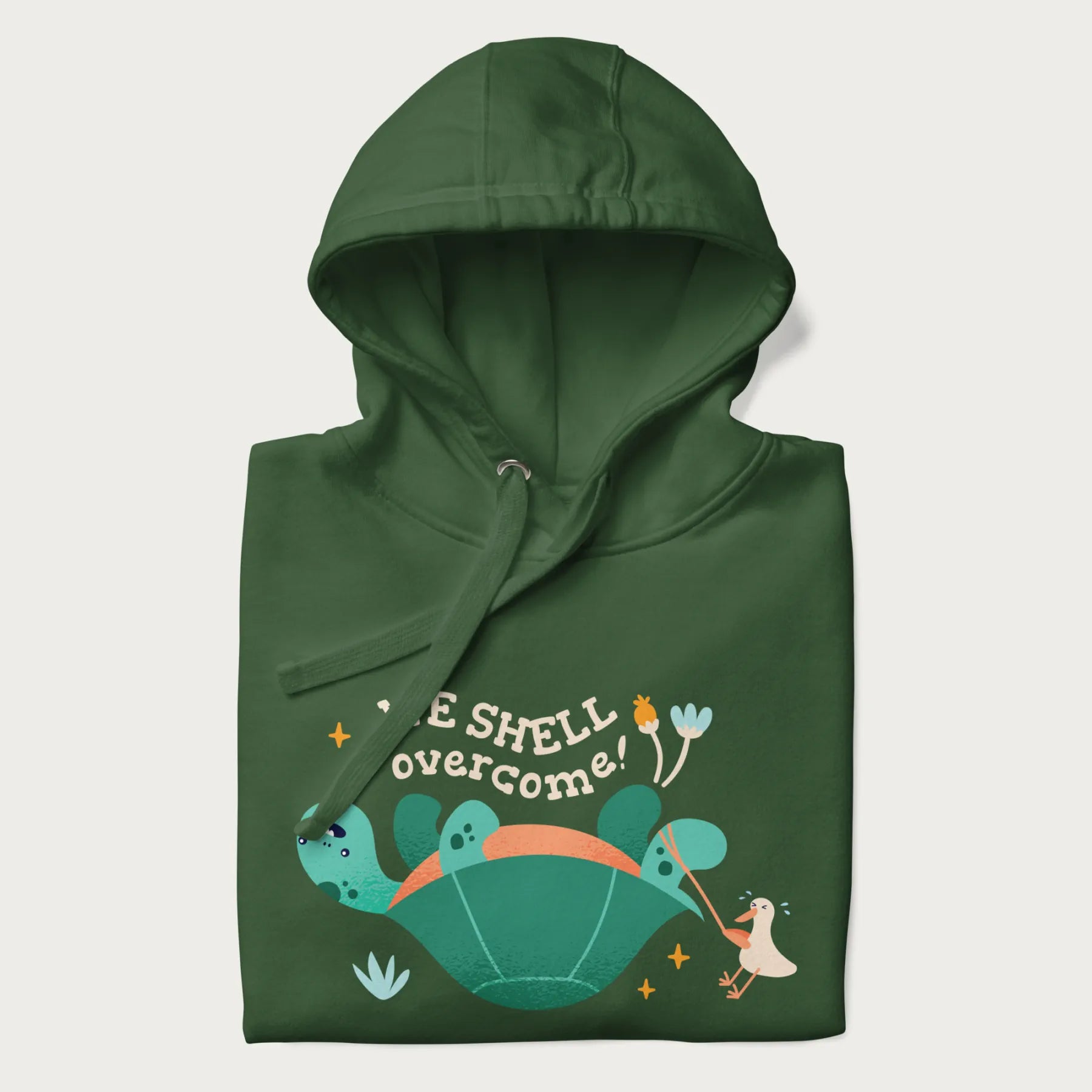 Folded forest green hoodie with graphic of a turtle and a duck with the text 'We Shell Overcome'.