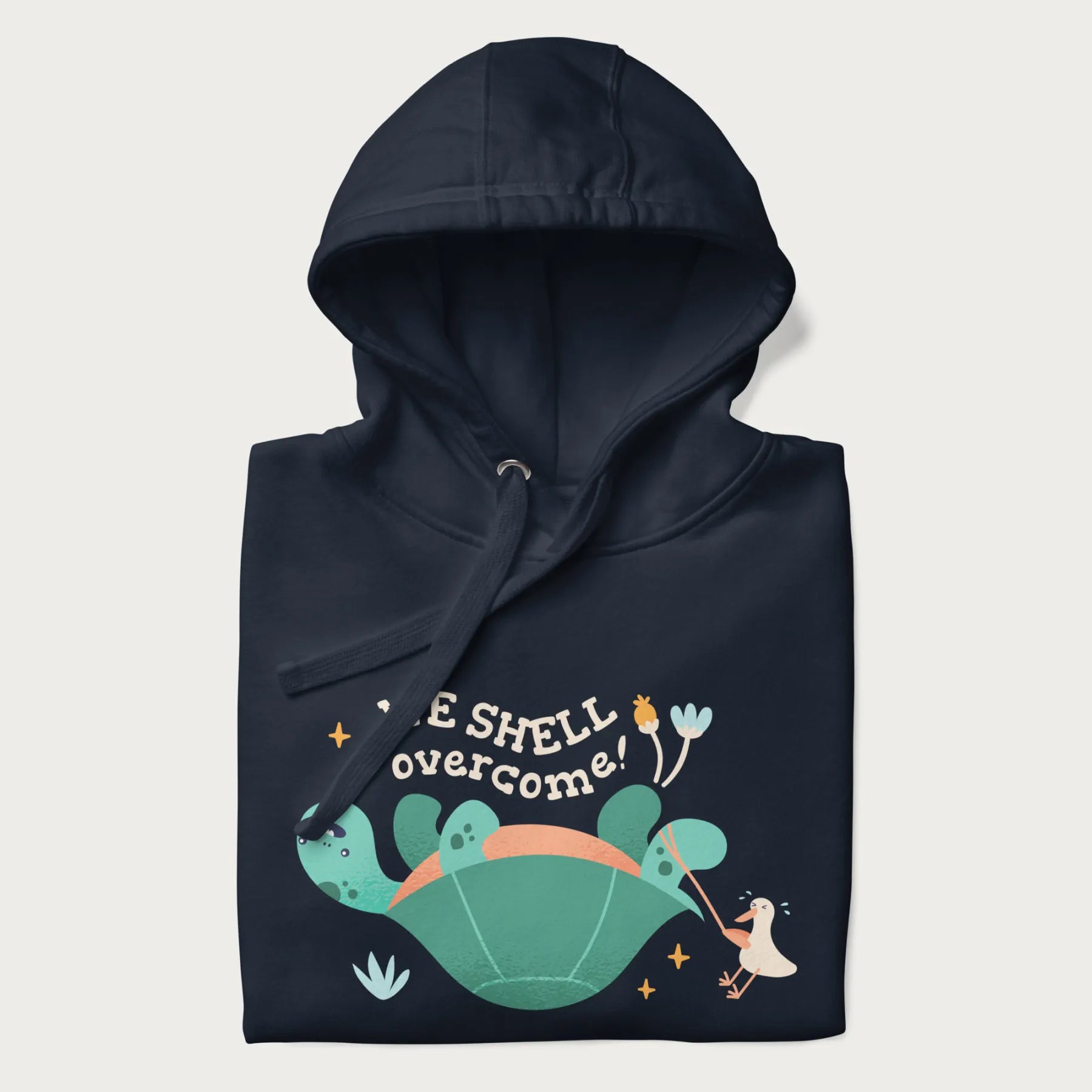 Folded navy blue hoodie with graphic of a turtle and a duck with the text 'We Shell Overcome'.