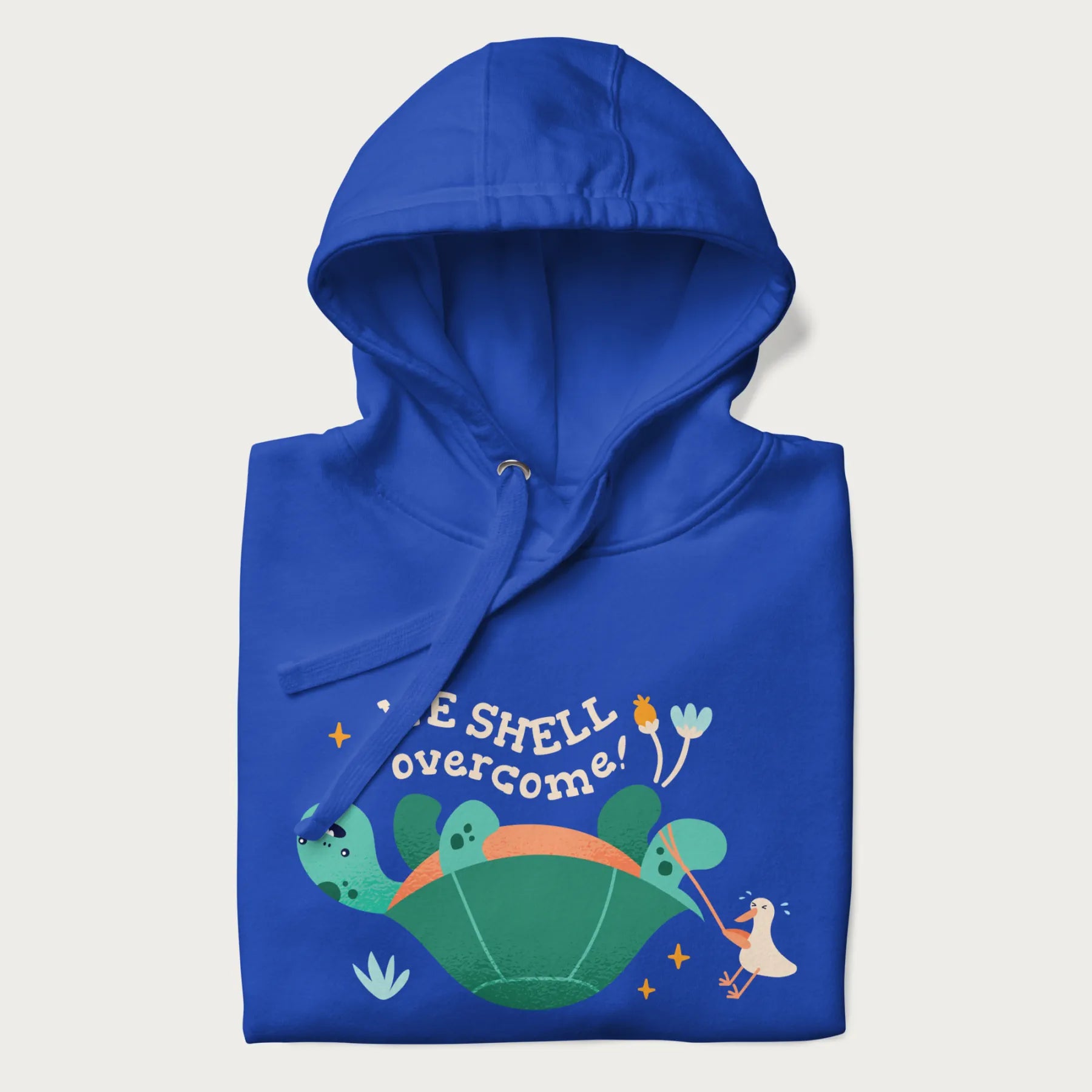 Folded royal blue hoodie with graphic of a turtle and a duck with the text 'We Shell Overcome'.
