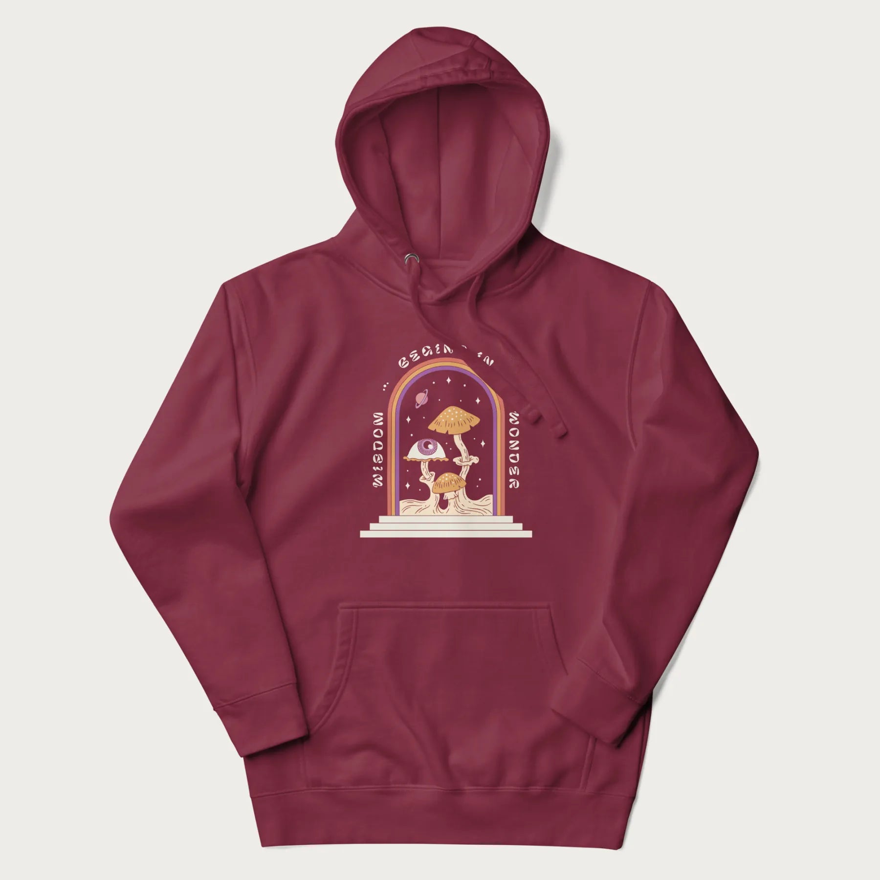 Maroon hoodie with graphic of mystical mushrooms with an all-seeing eye and the text 'Wisdom Begins in Wonder' framed by a rainbow arch.