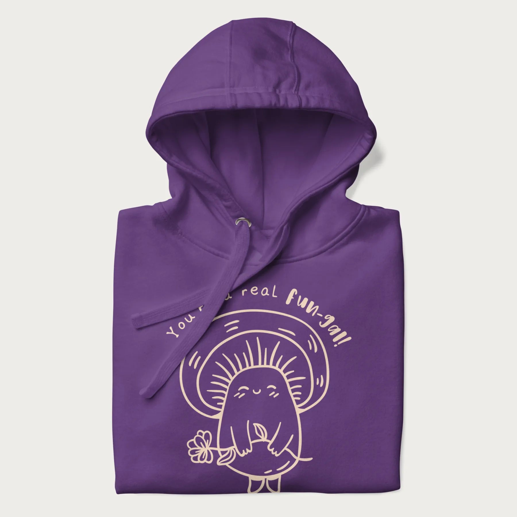 Folded purple hoodie with graphic of a cute mushroom holding a flower and the text "You're a Real Fun-gal!"