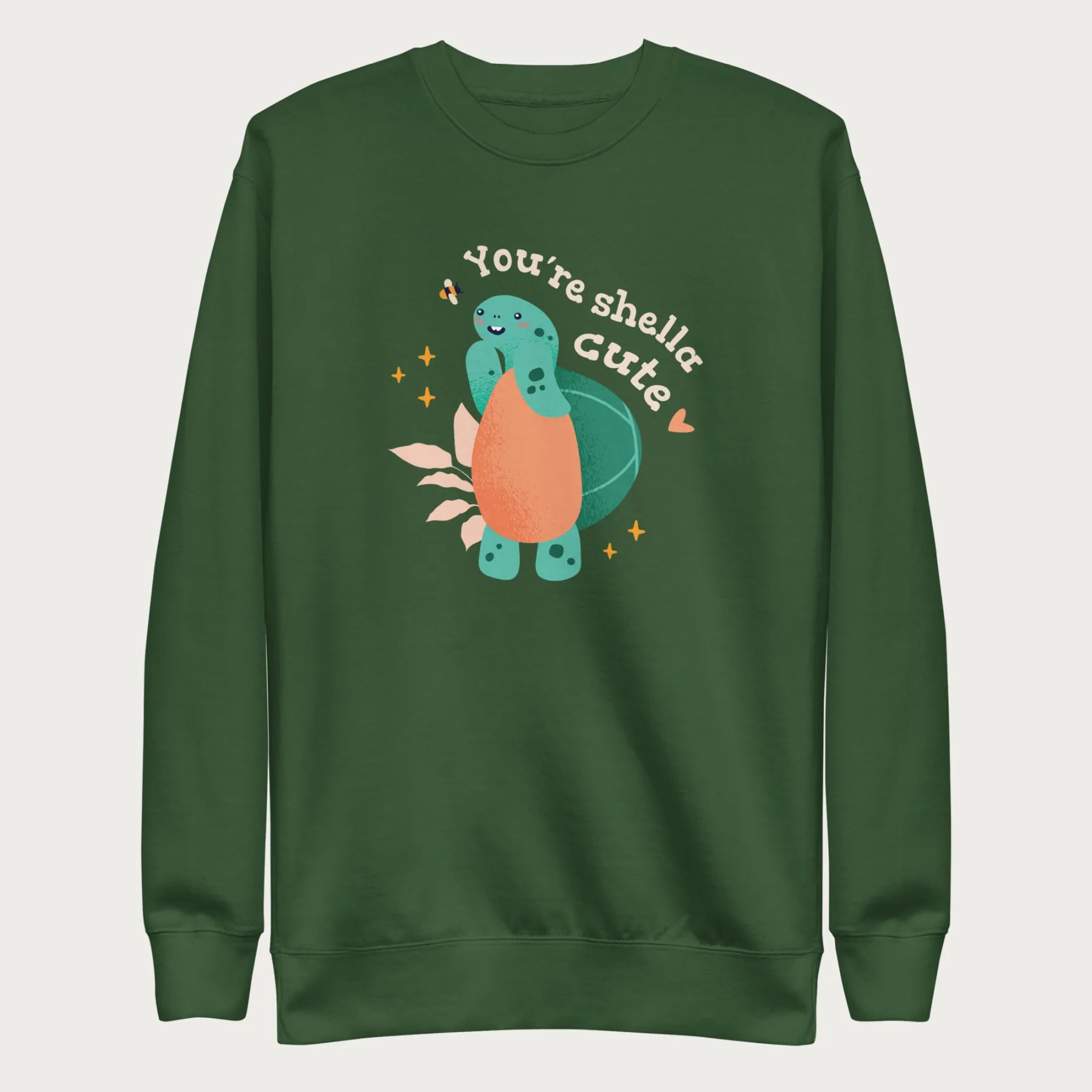 Forest green sweatshirt with a cute graphic of a smiling turtle and bee with the phrase 'You're Shella Cute.'