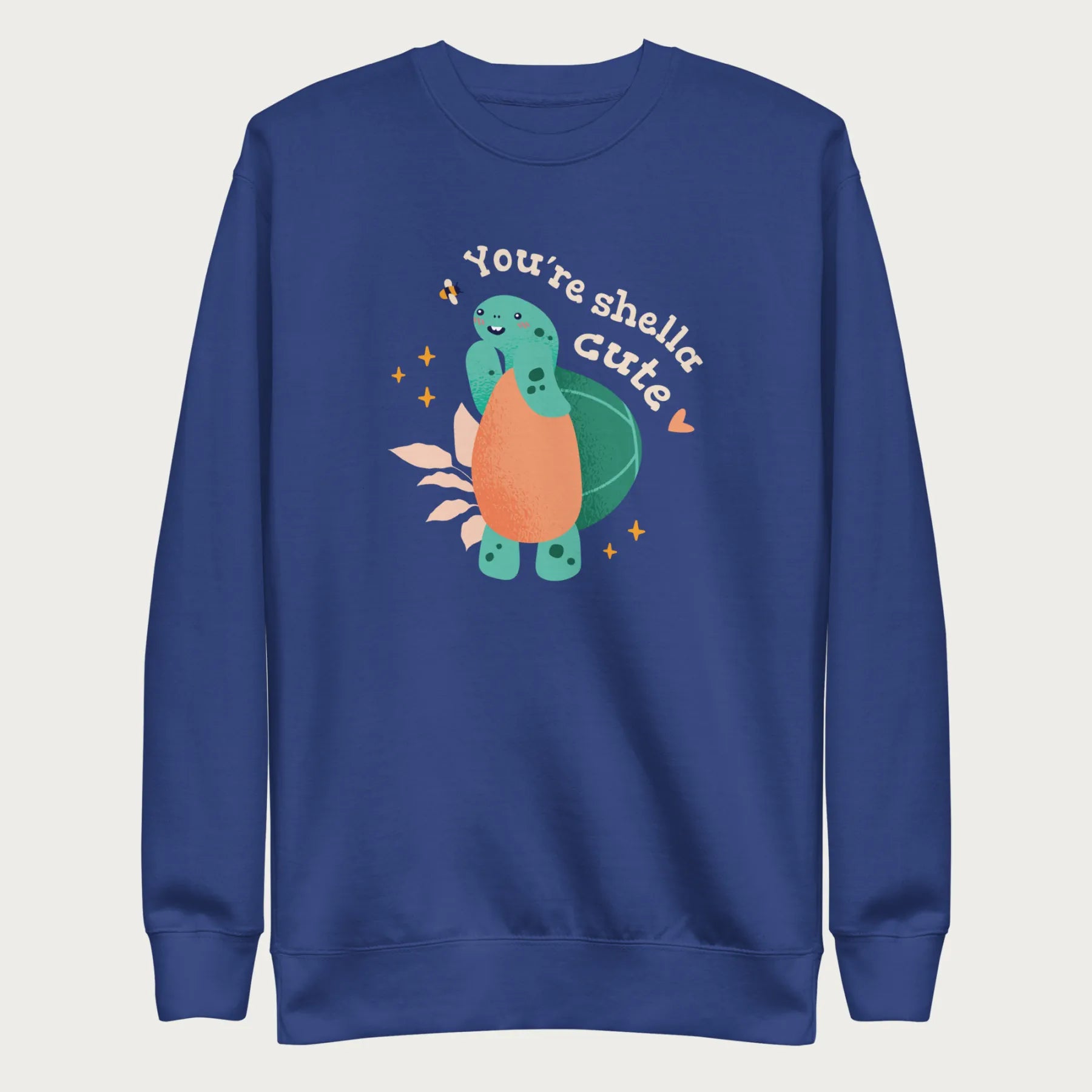 Royal blue sweatshirt with a cute graphic of a smiling turtle and bee with the phrase 'You're Shella Cute.'