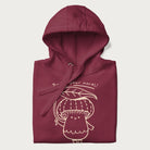 Folded maroon hoodie with graphic of a cute mushroom holding a leaf with the text "Boost Your Morel."