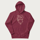 Maroon hoodie with graphic of a cute mushroom holding a leaf with the text "Boost Your Morel."