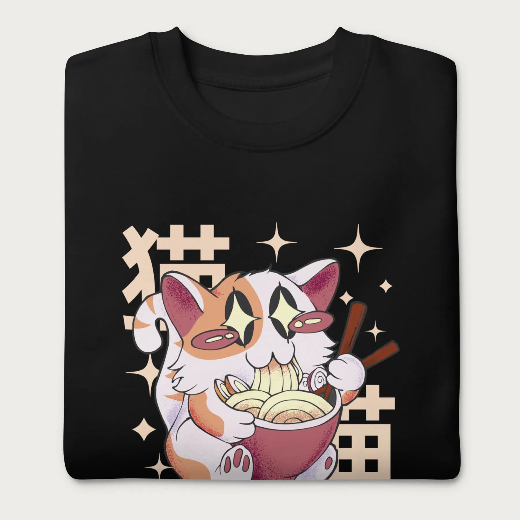 Folded black sweatshirt with Japanese text and a graphic of a kawaii cat eating ramen.