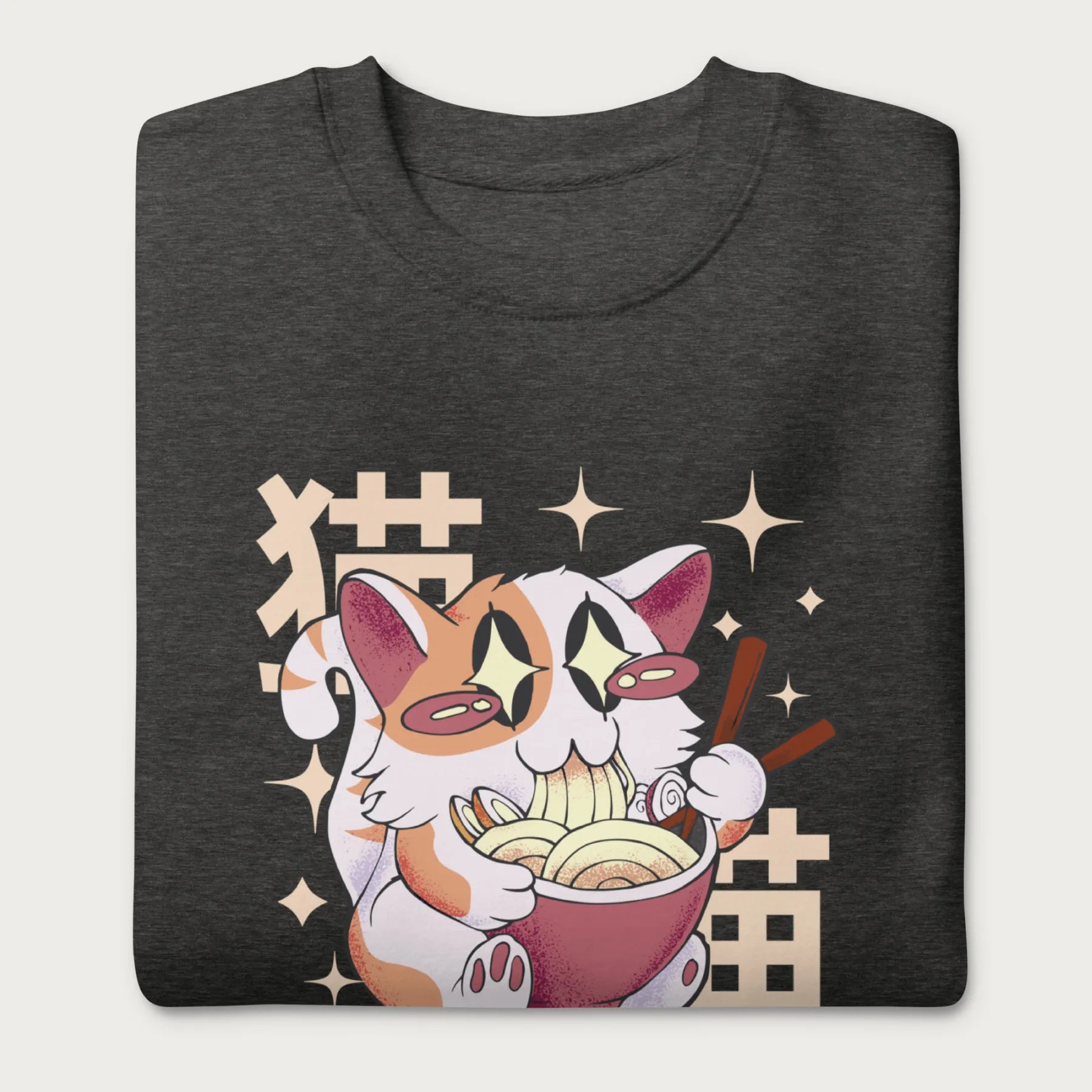 Folded dark grey sweatshirt with Japanese text and a graphic of a kawaii cat eating ramen.