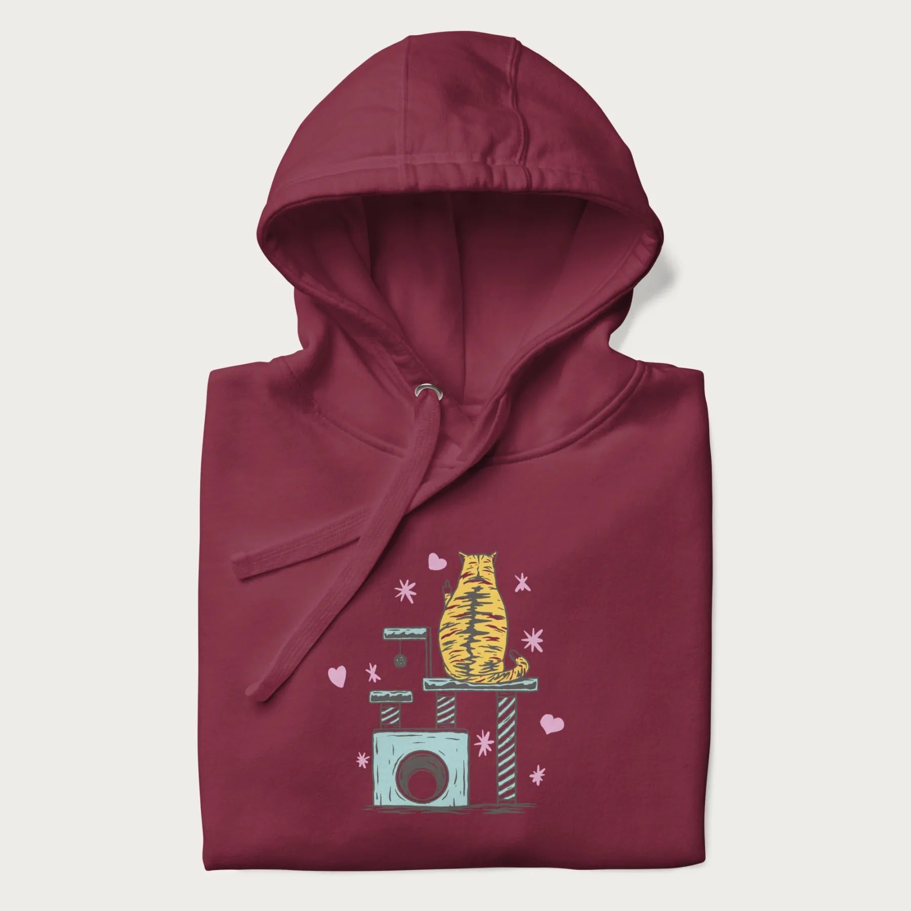 Folded maroon hoodie with graphic of a tabby cat on a scratching post, raising its middle finger.