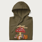 Folded military green hoodie with animal around a festively decorated mushroom and the text 'Christmas with the Beloved' above.