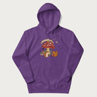 Purple hoodie with animal around a festively decorated mushroom and the text 'Christmas with the Beloved' above.