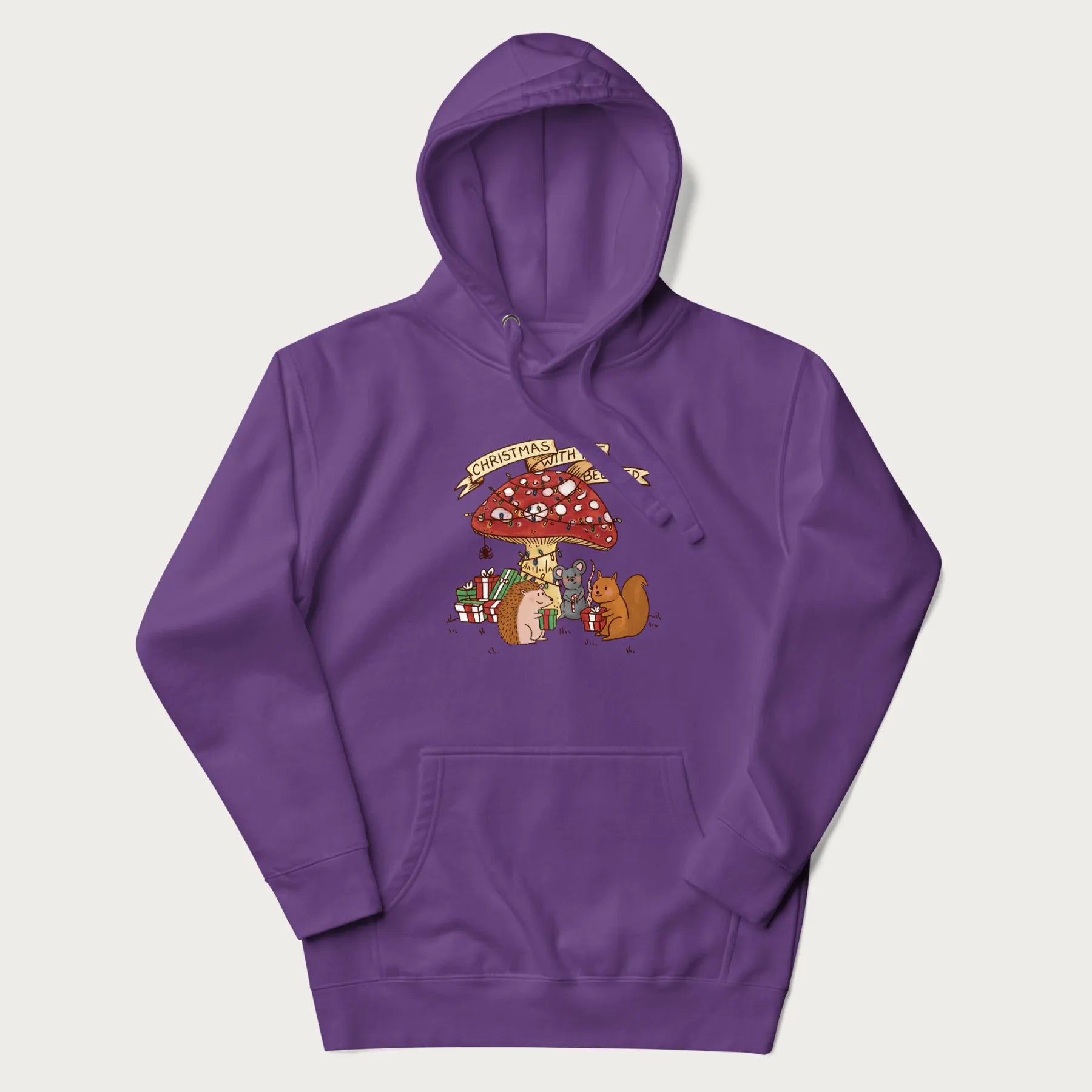 Purple hoodie with animal around a festively decorated mushroom and the text 'Christmas with the Beloved' above.