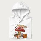 Folded white hoodie with animal around a festively decorated mushroom and the text 'Christmas with the Beloved' above.