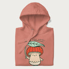 Folded light pink hoodie with a graphic of an adorable mushroom character with a red cap and the text 'Boost your morel!'.