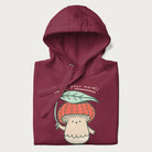 Folded maroon hoodie with a graphic of an adorable mushroom character with a red cap and the text 'Boost your morel!'.