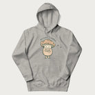 Light grey hoodie with a graphic of an adorable mushroom character and the text 'Shiitake Happens'.